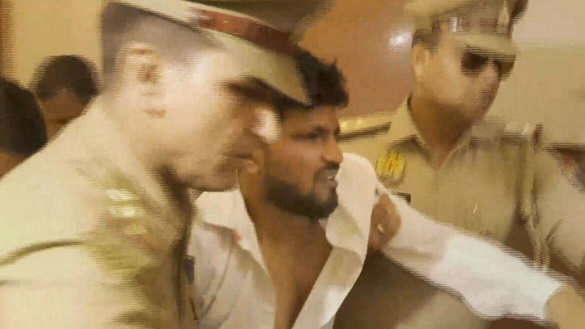 <div class="paragraphs"><p>Police officials detain a person who allegedly hurled shoe at Samajwadi Party leader Swami Prasad Maurya, in Lucknow.</p></div>