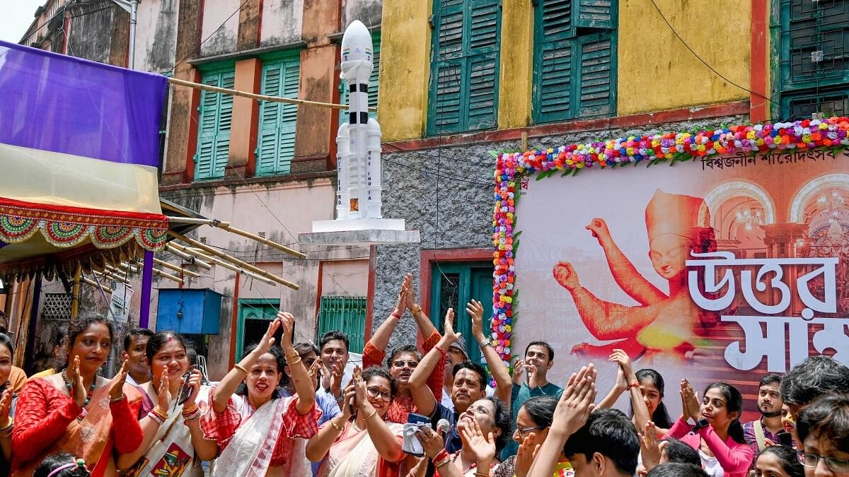 <div class="paragraphs"><p>Devotees clap as a model of 'Chandrayaan 3' flies with the help of a drone during an event to celebrate the soft landing of the spacecraft on the moon in Kolkata.&nbsp;</p></div>