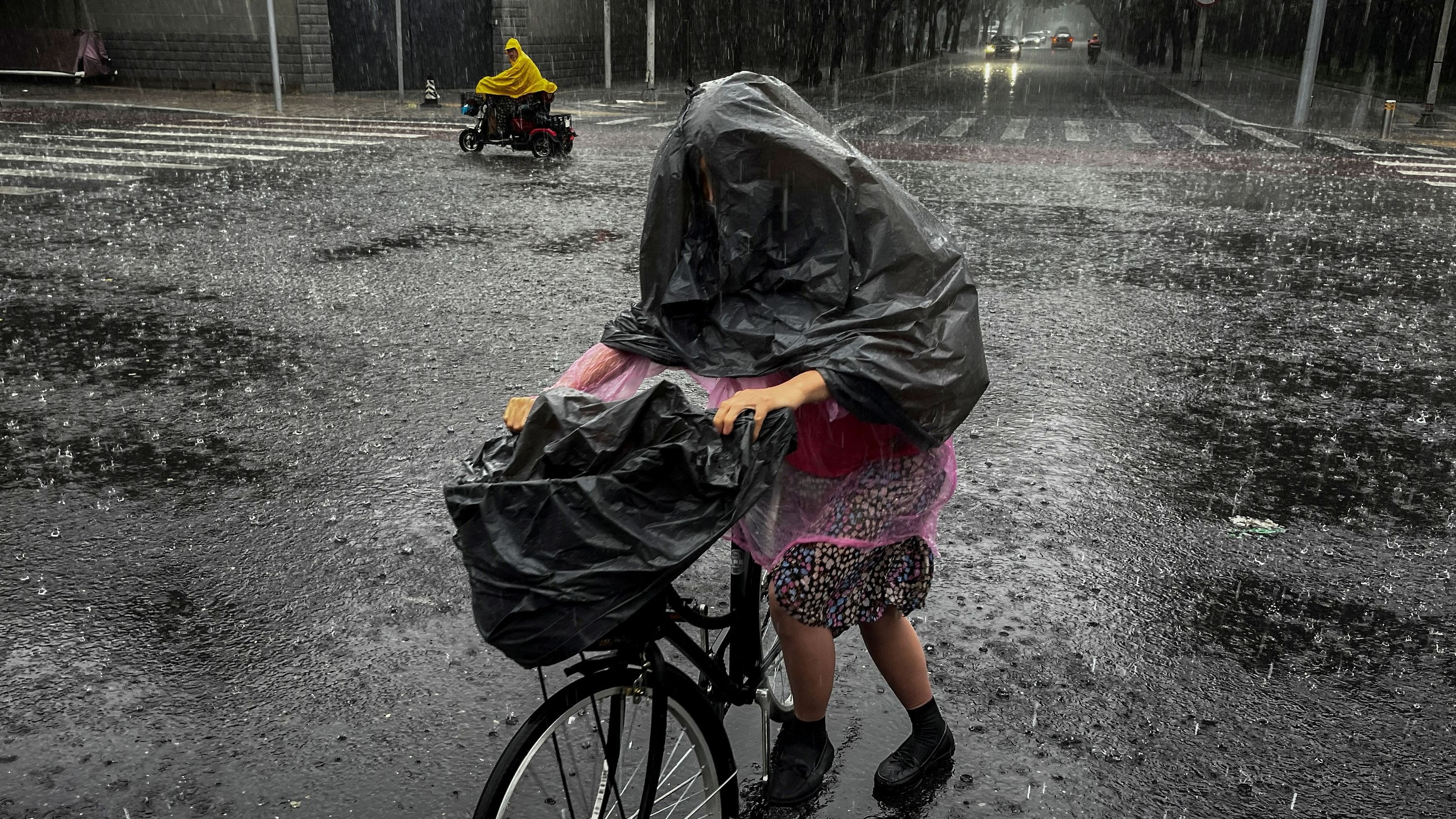 <div class="paragraphs"><p>A woman wears a trash bag over her head to protect herself from heavy rain during a sudden downpour in Beijing, China.</p></div>