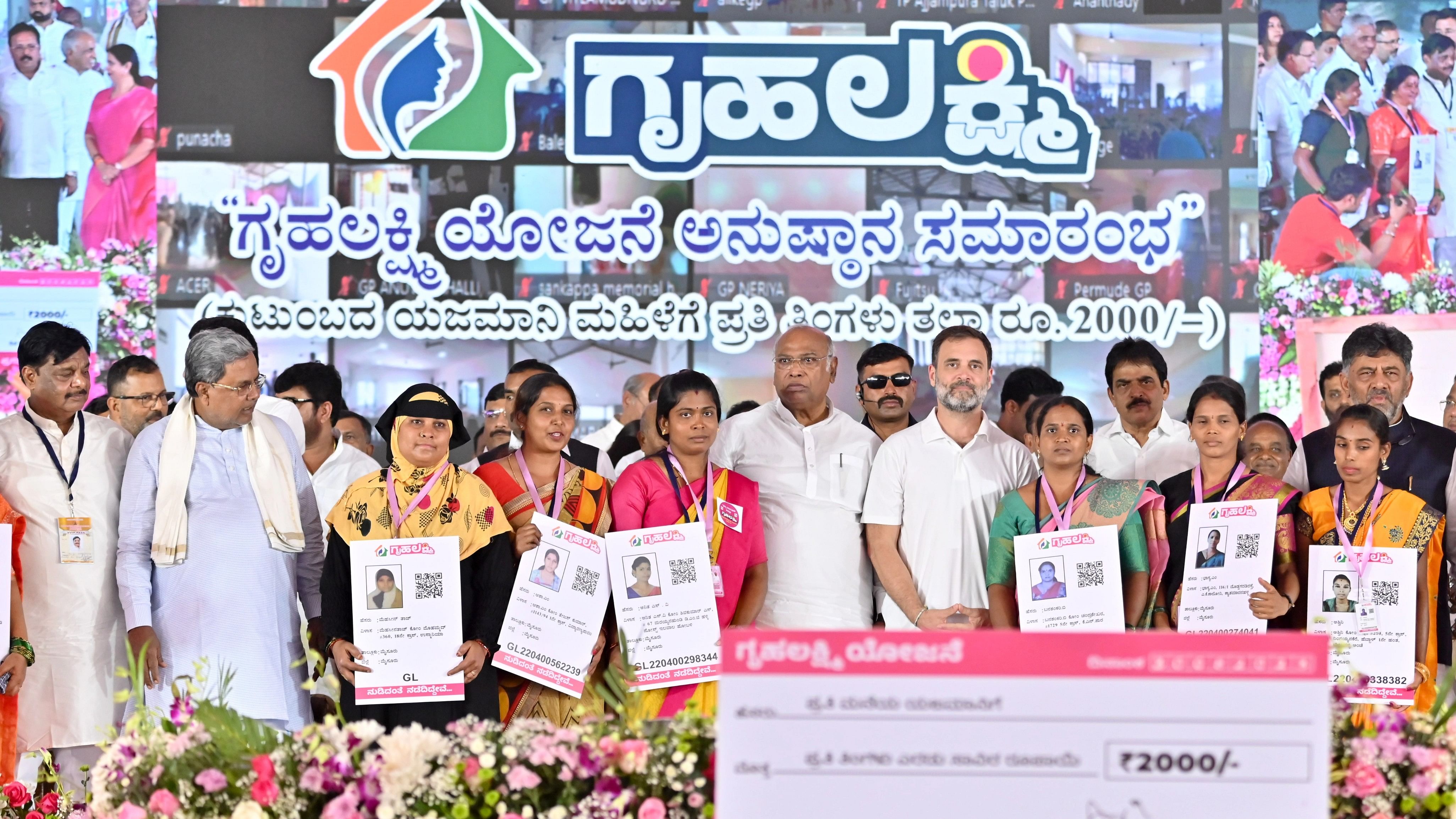 <div class="paragraphs"><p>Congress leader and MP Rahul Gandhi distributed digital cards of the Gruha Lakshmi scheme to beneficiaries at the launch of the scheme in Mysuru on Wednesday. Minister H C Mahadevappa, Chief Minister Siddaramaiah, Congress president Mallikarjun Kharge, the party’s general secretary K C Venugopal and Deputy Chief Minister D K Shivakumar are seen. </p></div>