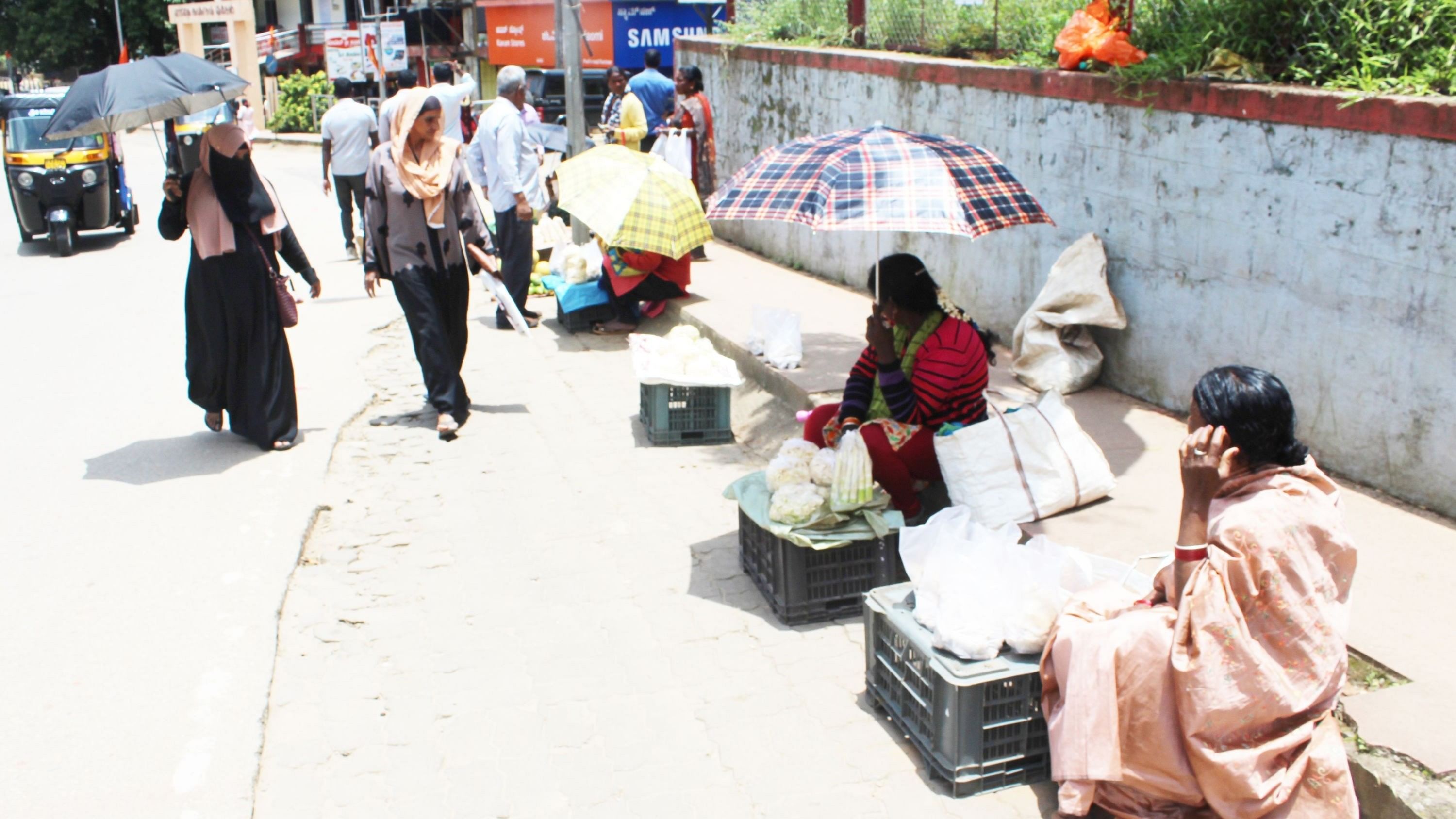<div class="paragraphs"><p>People and street vendors use umbrellas to protect themselves from the scorching sun in Madikeri, an unusual scene in August.&nbsp;</p></div>