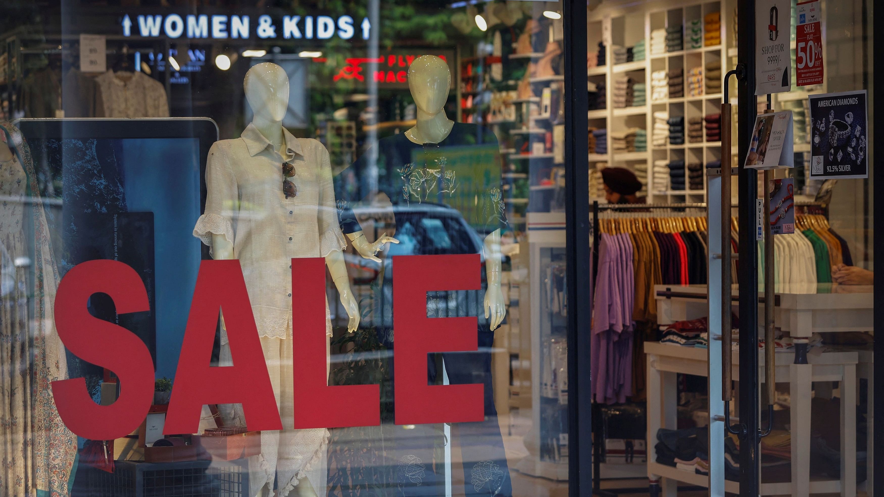 <div class="paragraphs"><p>A salesman stands inside a retail store with a sign advertising a sale in New Delhi.</p></div>