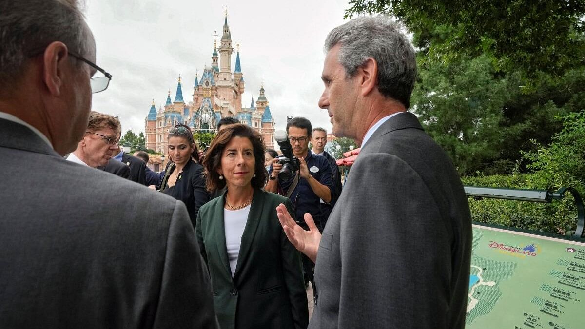 <div class="paragraphs"><p>US Commerce Secretary Gina Raimondo, chats with officials as she tours the Shanghai Disneyland in China.</p></div>