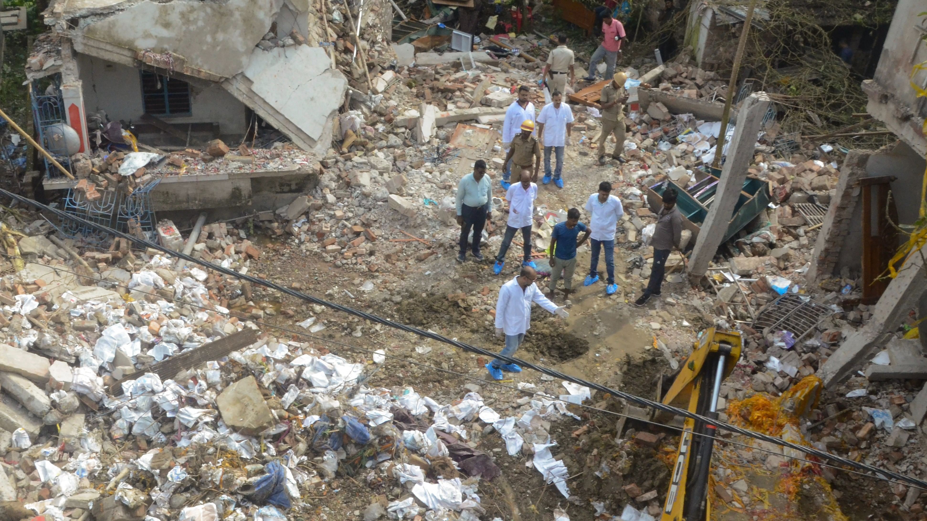 <div class="paragraphs"><p>Forensic experts collect evidence from the blast site of an illegal firecracker factory.&nbsp;</p></div>