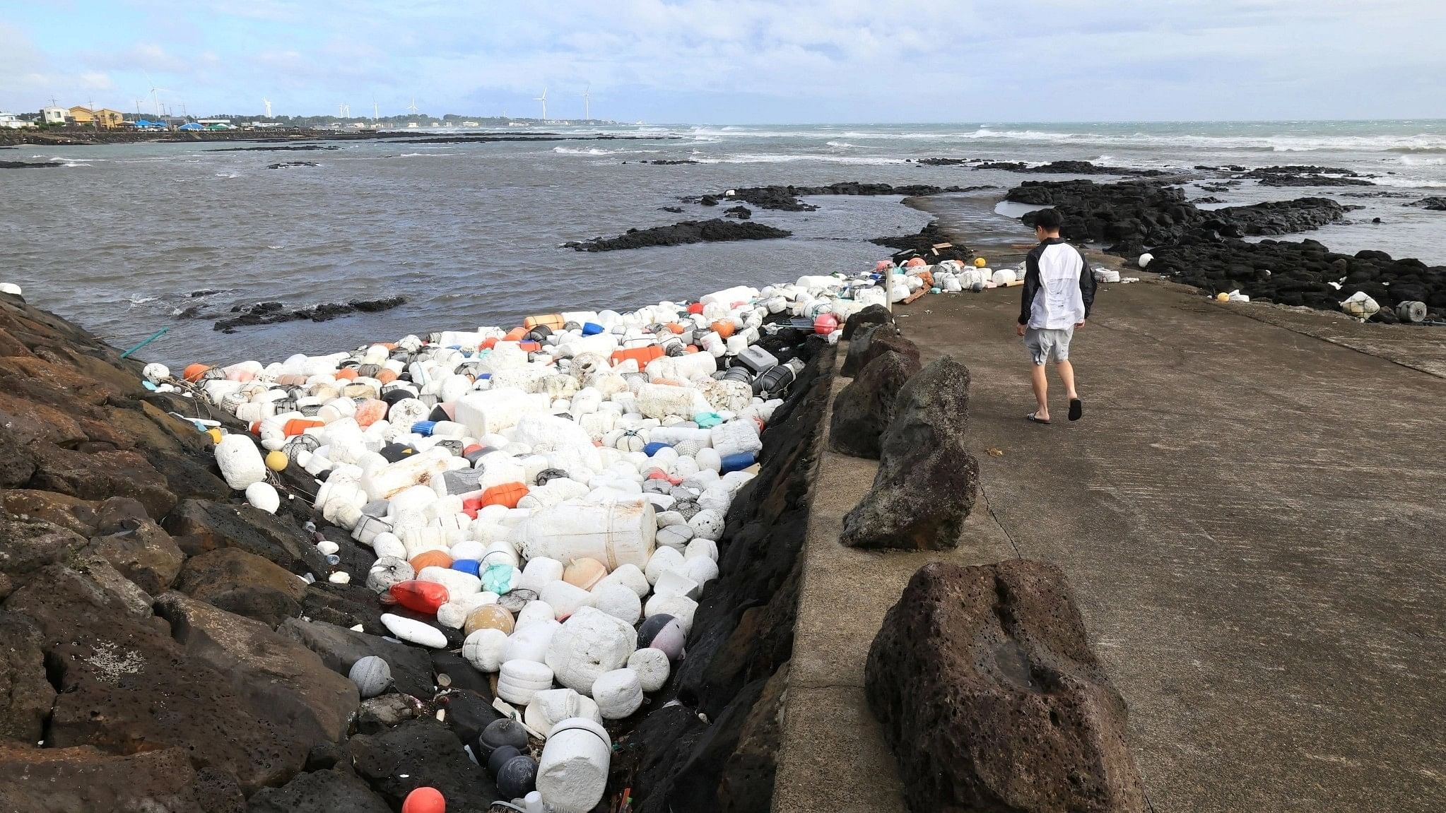 <div class="paragraphs"><p>A man looks at plastic waste after typhoon Khanun's passing at a port on Jeju island, South Korea, August 10, 2023.</p></div>