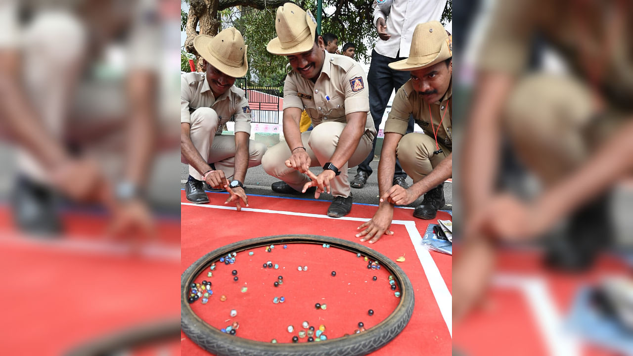 <div class="paragraphs"><p>Policemen play marbles, called Goli Aata, during various cultural and sporting events held at the Sree Kanteerava Stadium on Tuesday to mark the National Sports Day. </p></div>