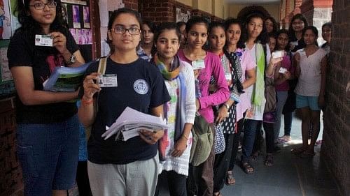<div class="paragraphs"><p>Students with their I.D. cards wait to cast their votes in the DUSU election at the North Campus of Delhi University in New Delhi on Friday. </p></div>