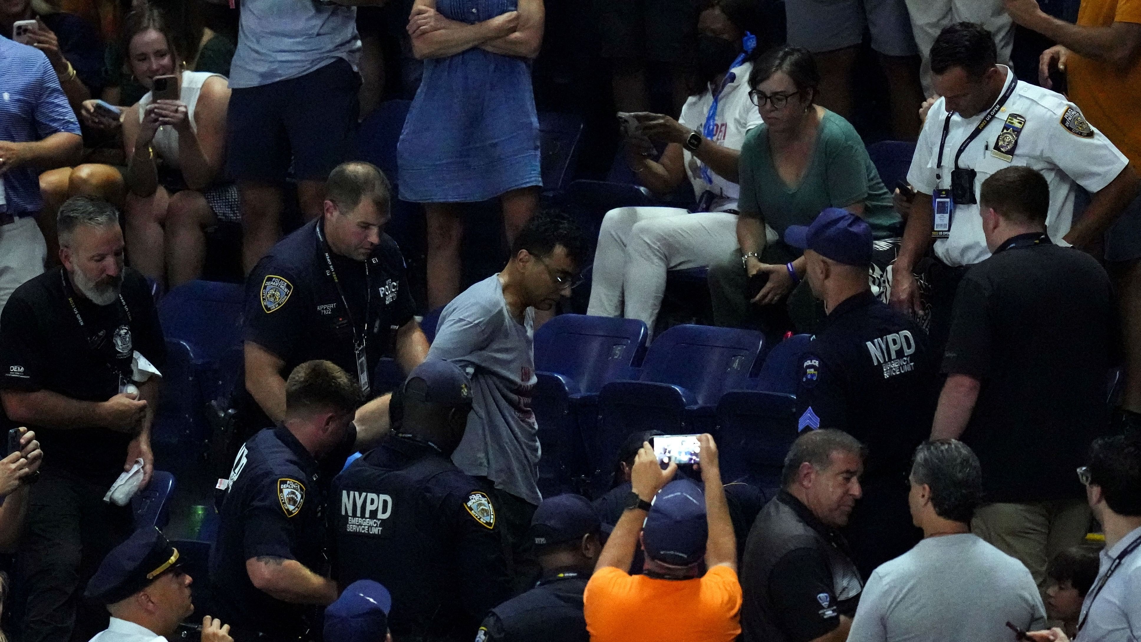 <div class="paragraphs"><p> Police officers remove a climate change protester as play is suspended in the second set of the women's semifinal between Coco Gauff of the United States and Karolina Muchova of Czech Republic on day eleven of the 2023 US Open tennis tournament at USTA Billie Jean King National Tennis Center. </p></div>
