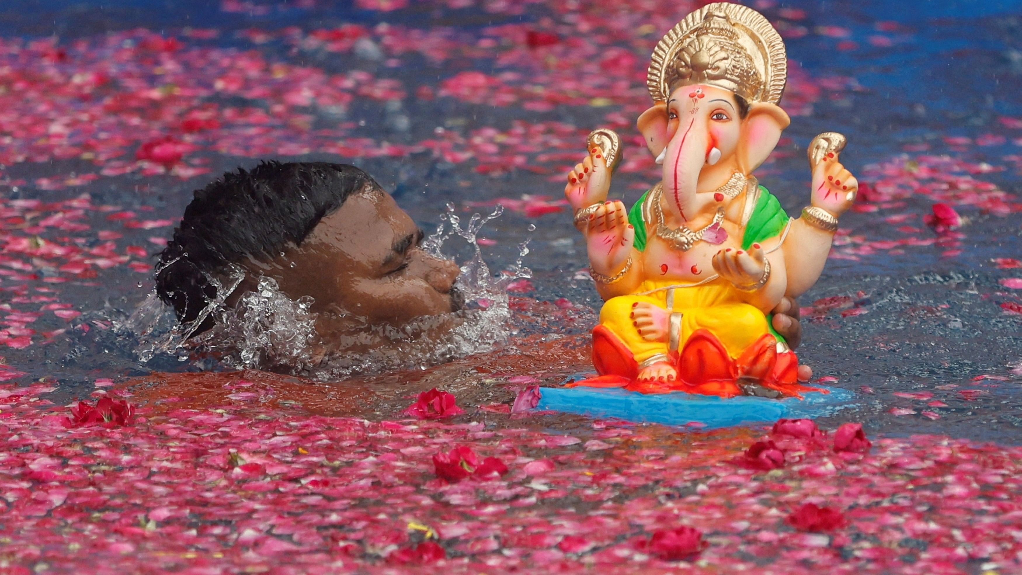 <div class="paragraphs"><p>A man immerses an idol of Ganesh during the ten-day-long Ganesh Chaturthi festival in Mumbai.&nbsp;</p></div>