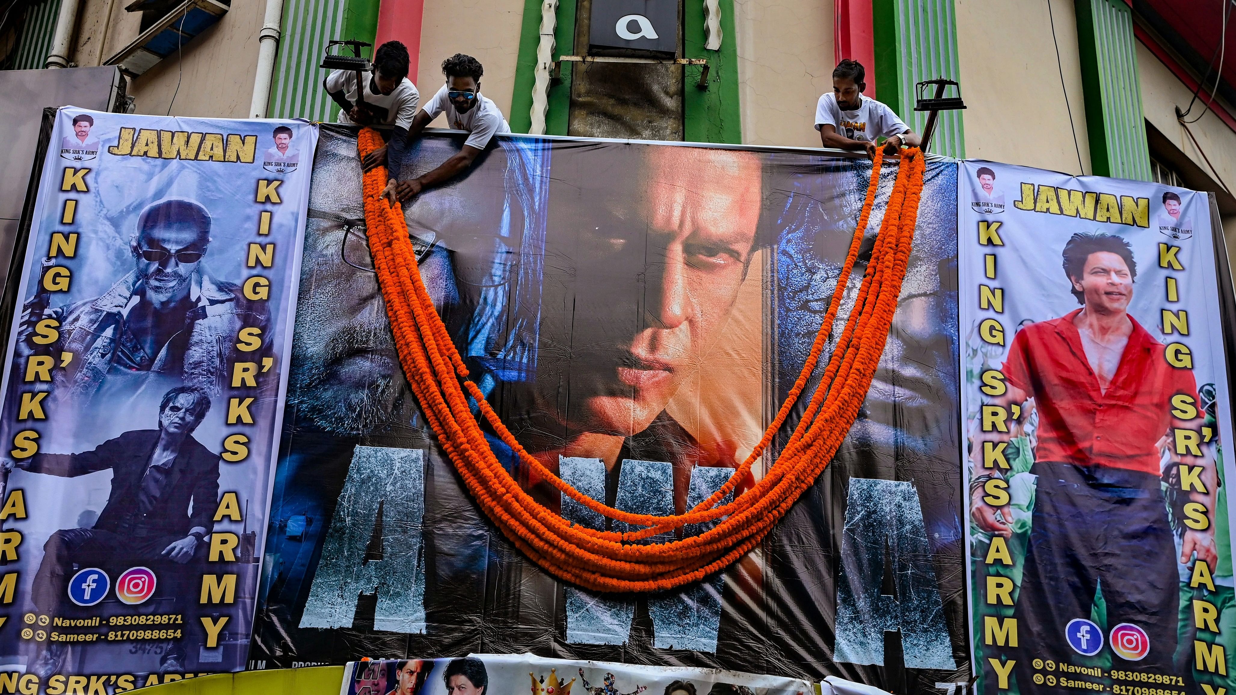 <div class="paragraphs"><p>Fans of actor Shah Rukh Khan hang garlands on the poster of his newly released movie Jawan at a cinema hall in Kolkata.</p></div>