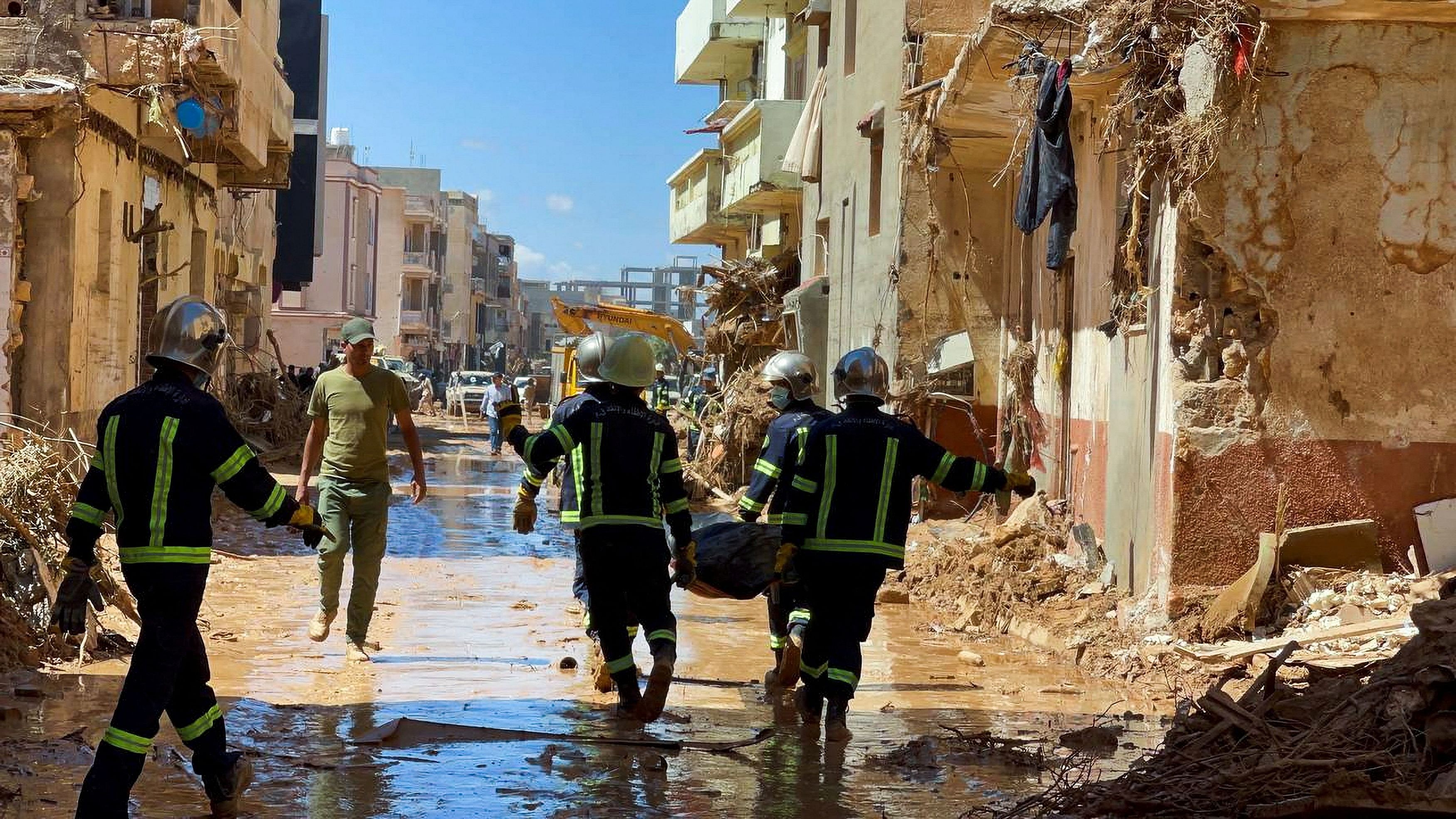 <div class="paragraphs"><p>Members of the rescue teams from the Egyptian army carry a dead body as they walk in the mud between the destroyed buildings, after a powerful storm and heavy rainfall hit Libya, in Derna, Libya September 13, 2023.</p></div>