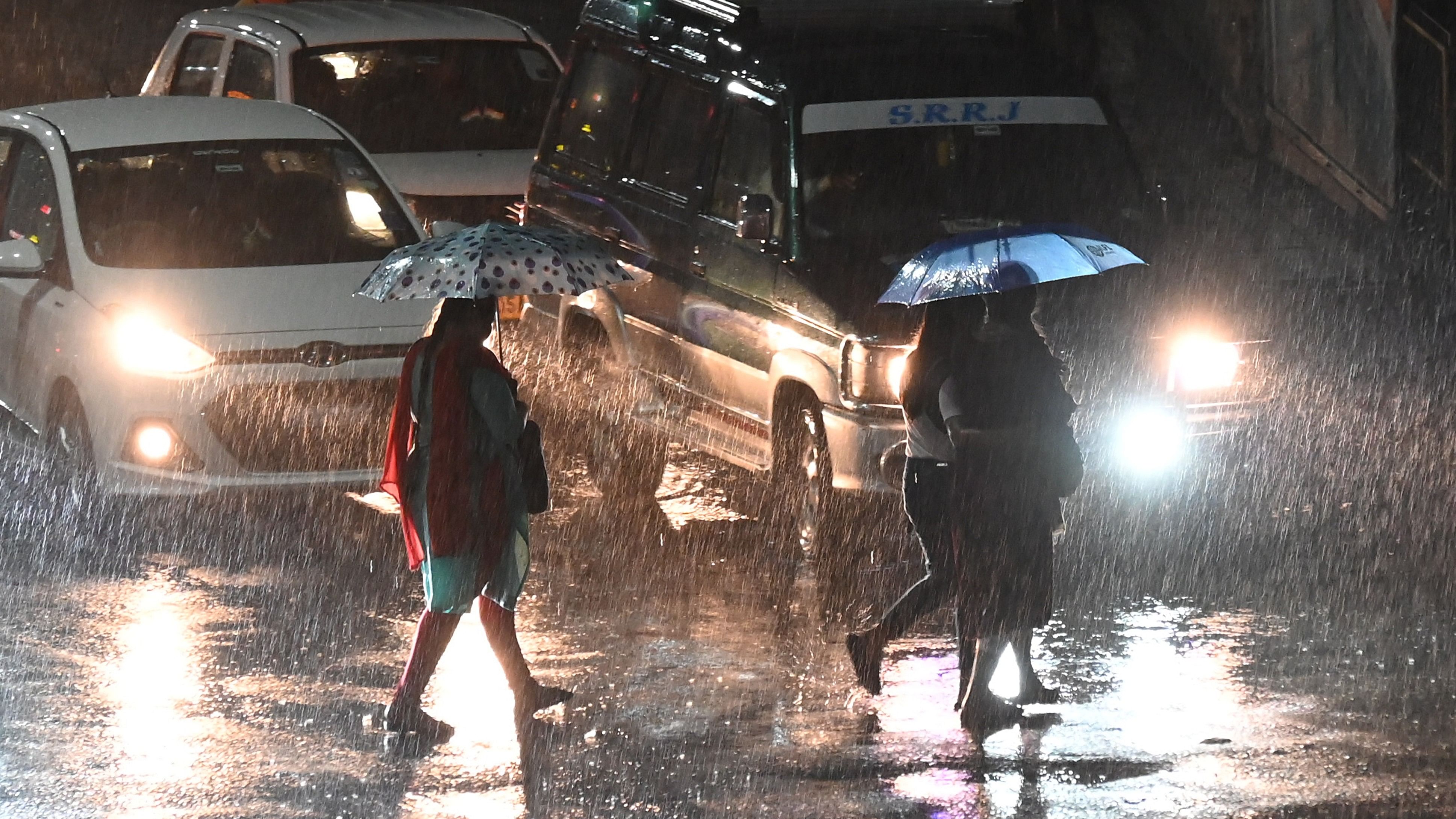 <div class="paragraphs"><p>People take refuge under umbrellas on a rainy Tuesday night. </p></div>