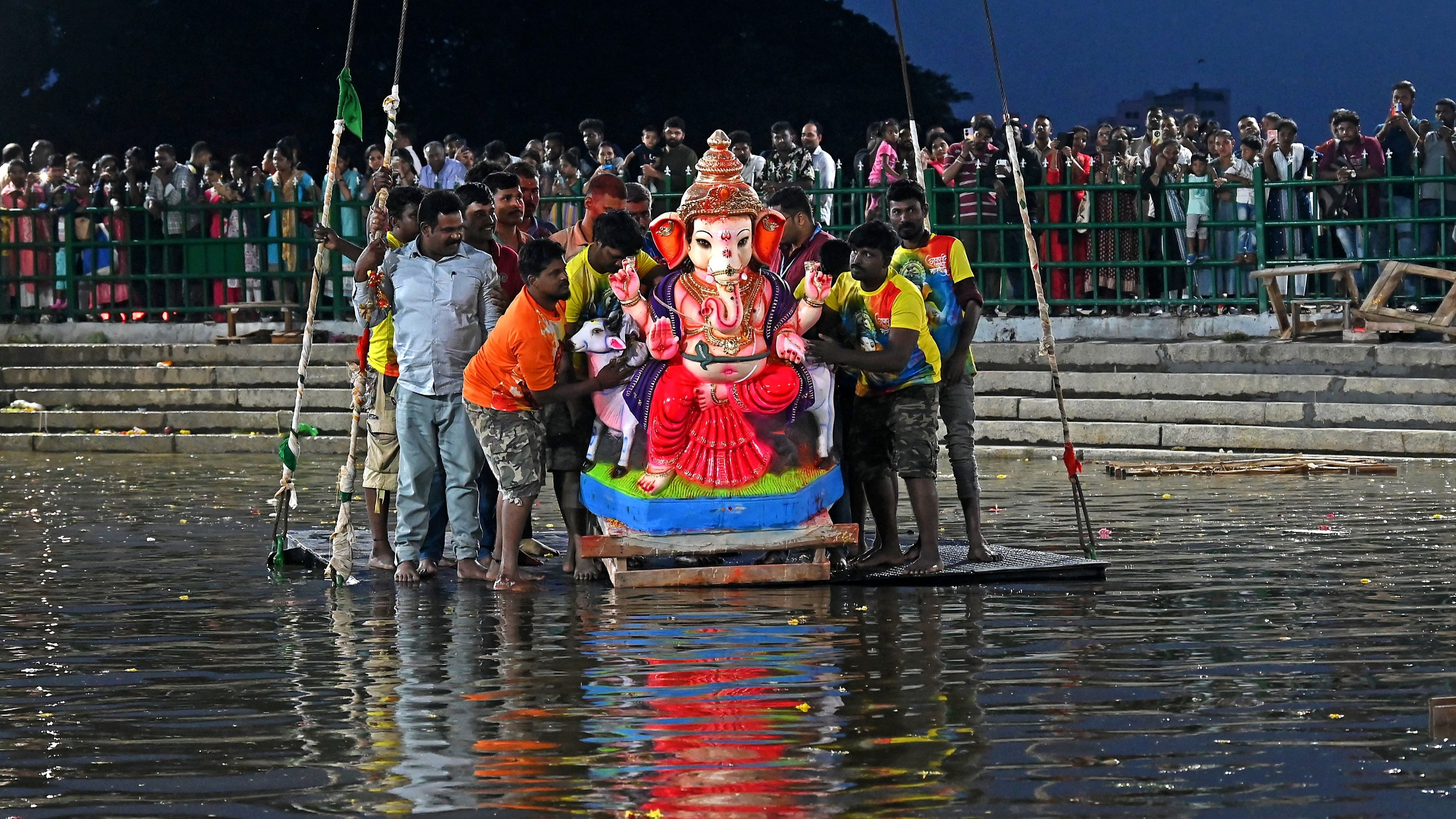 <div class="paragraphs"><p>Devotees gather at Halasuru lake to immerse Ganesha idols on Wednesday. </p></div>