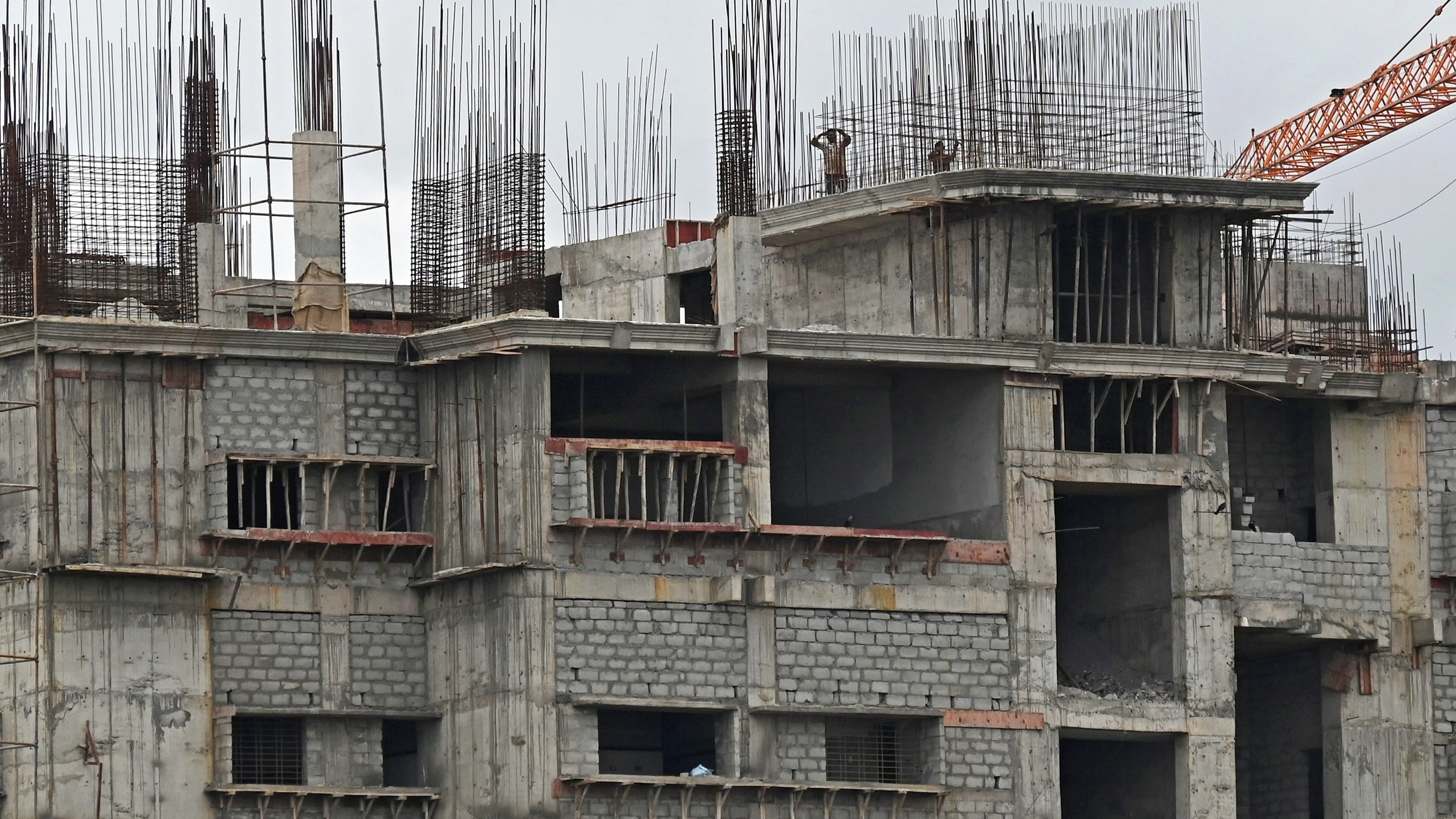 <div class="paragraphs"><p>Workers atop a construction building near Tharagupet, Bengaluru on Sunday.</p></div>