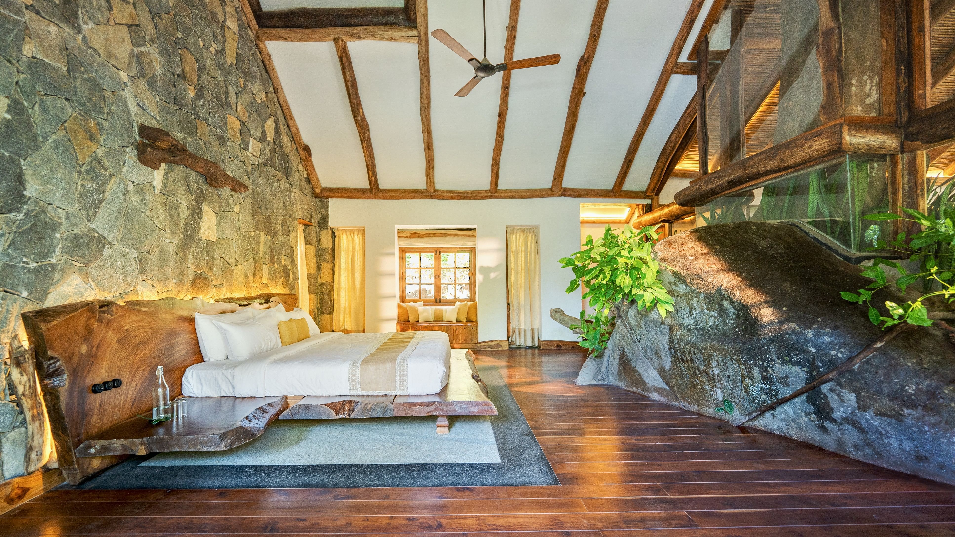 <div class="paragraphs"><p>This bedroom at a Wayanad home features a rock and a tree&nbsp;as part of its interiors. It was designed by Earthitects, Bengaluru.</p></div>