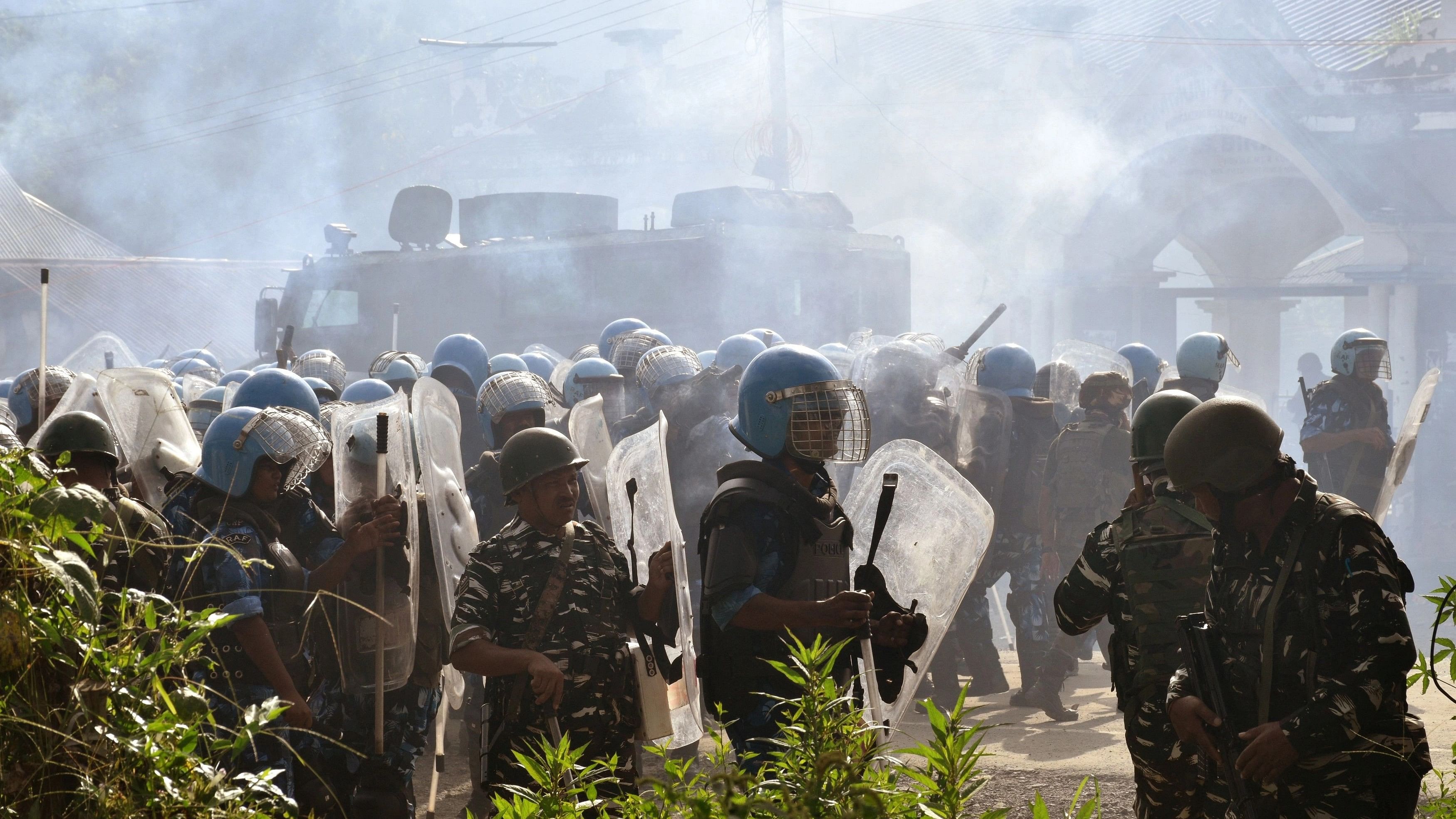 <div class="paragraphs"><p>Police officers stand amidst smoke billowing out from tear gas shells fired to disperse the crowd gathered to demand the removal of the army barricades in Bishnupur district, in the northeastern state of Manipur, India, September 6, 2023.</p></div>