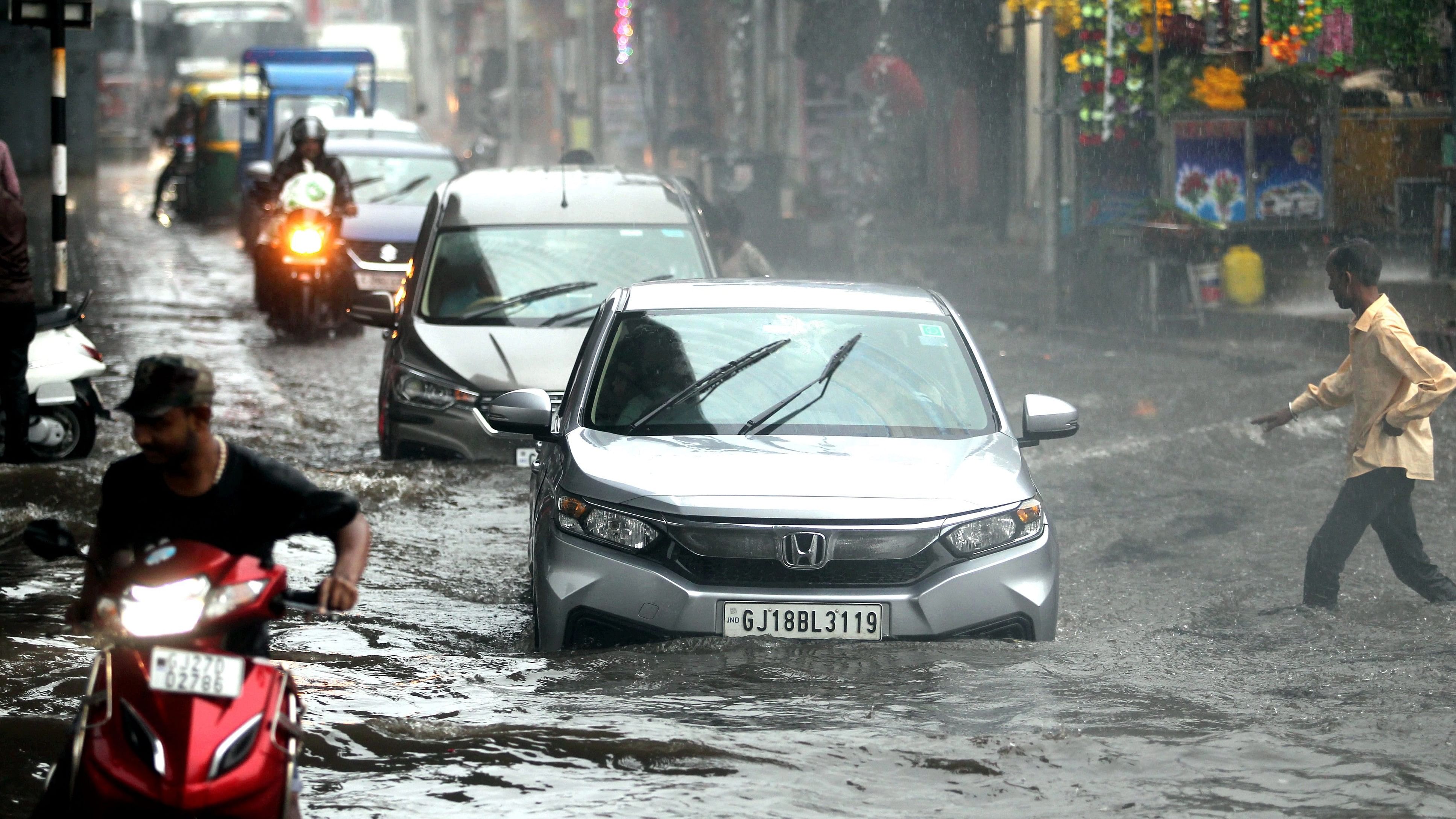 <div class="paragraphs"><p>Vehicles pass through a waterlogged road amid heavy rains, in Ahmedabad.</p></div>