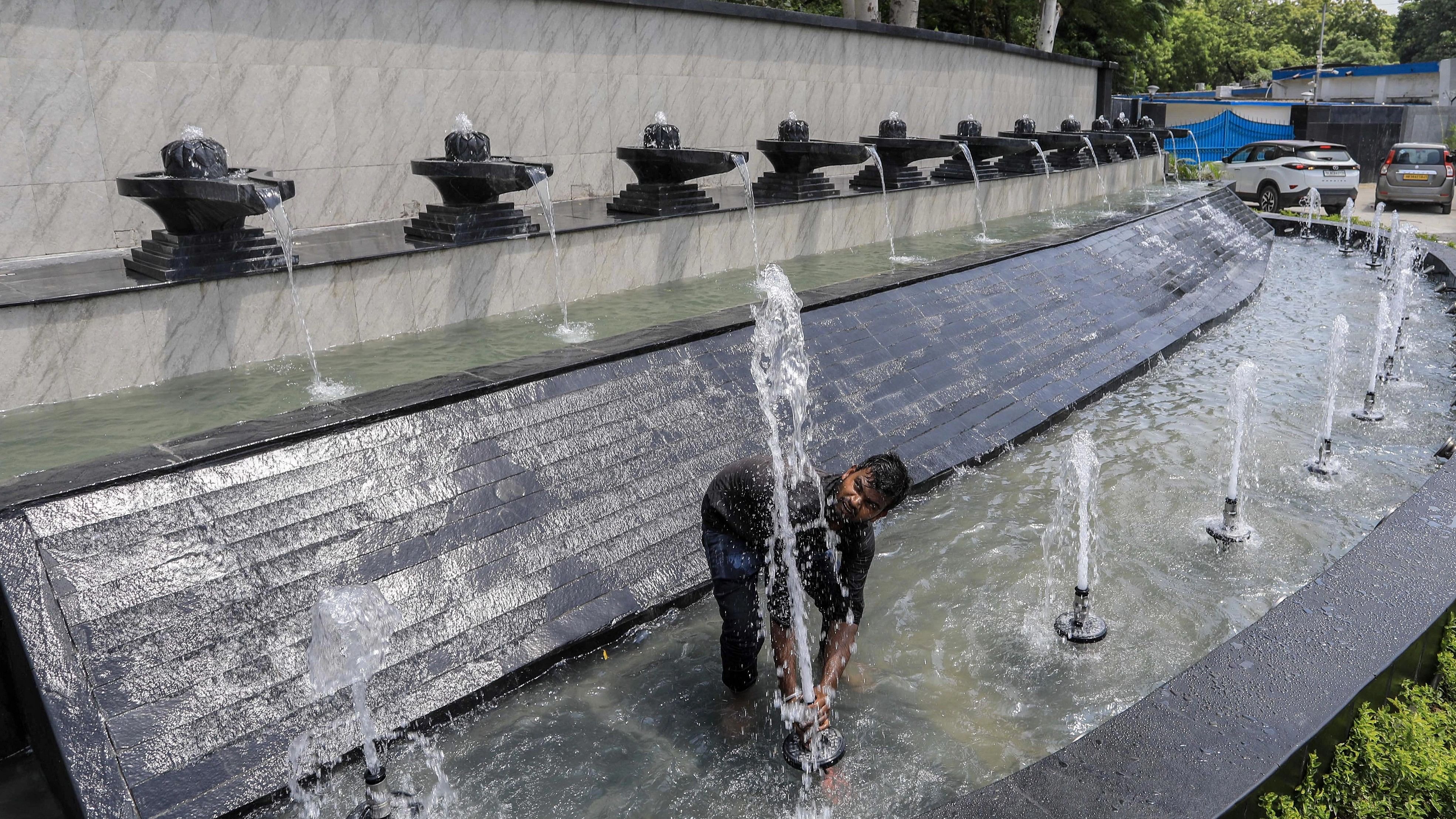 <div class="paragraphs"><p>A worker adjusts the height of a fountain near the 'Shivlings' installed as fountains at Yakshini Chowk ahead of the G20 Summit, in New Delhi.</p></div>