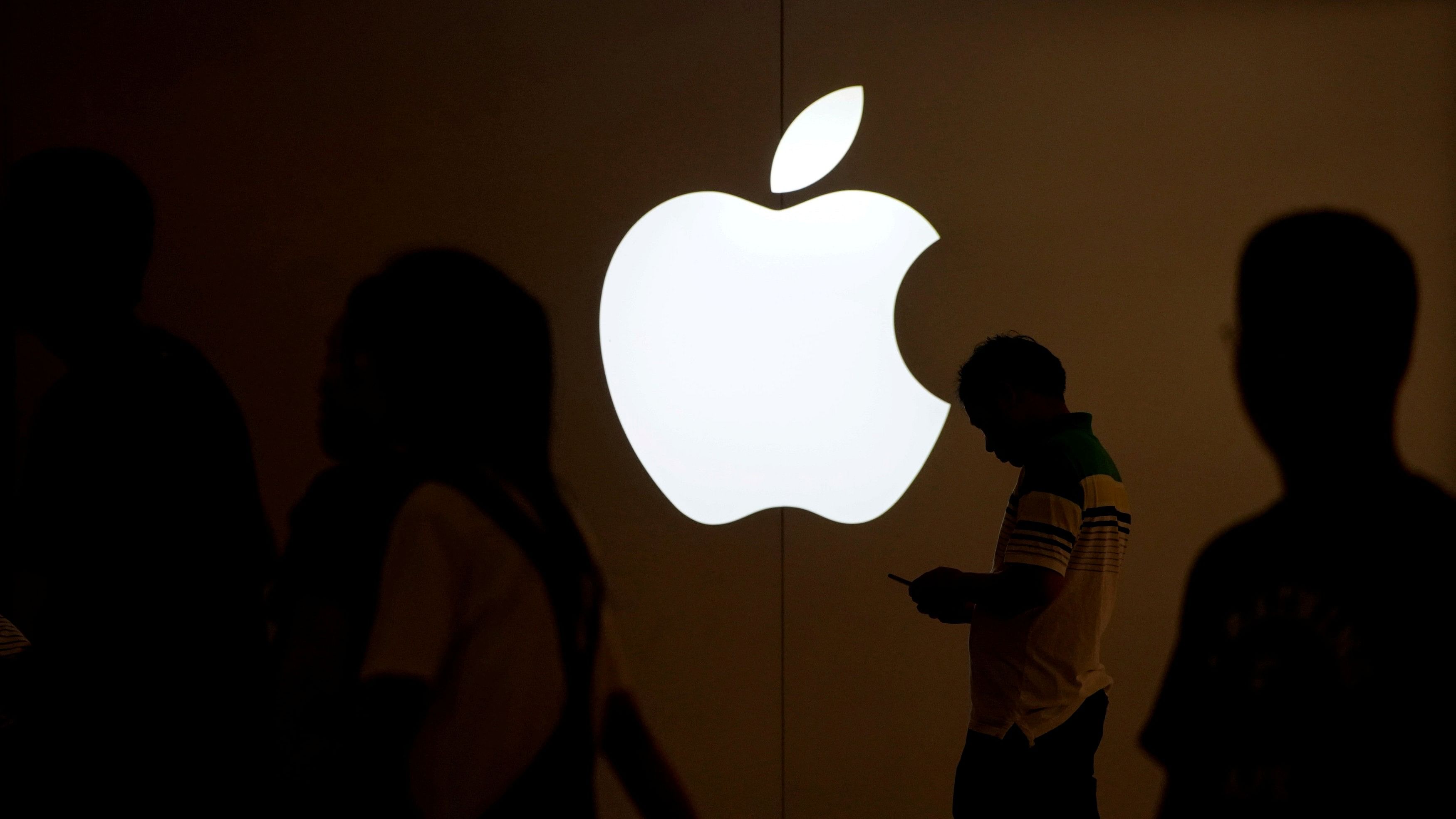 <div class="paragraphs"><p>A man looks at the screen of his mobile phone in front of an Apple logo outside its store in Shanghai, China on July 30, 2017.</p></div>