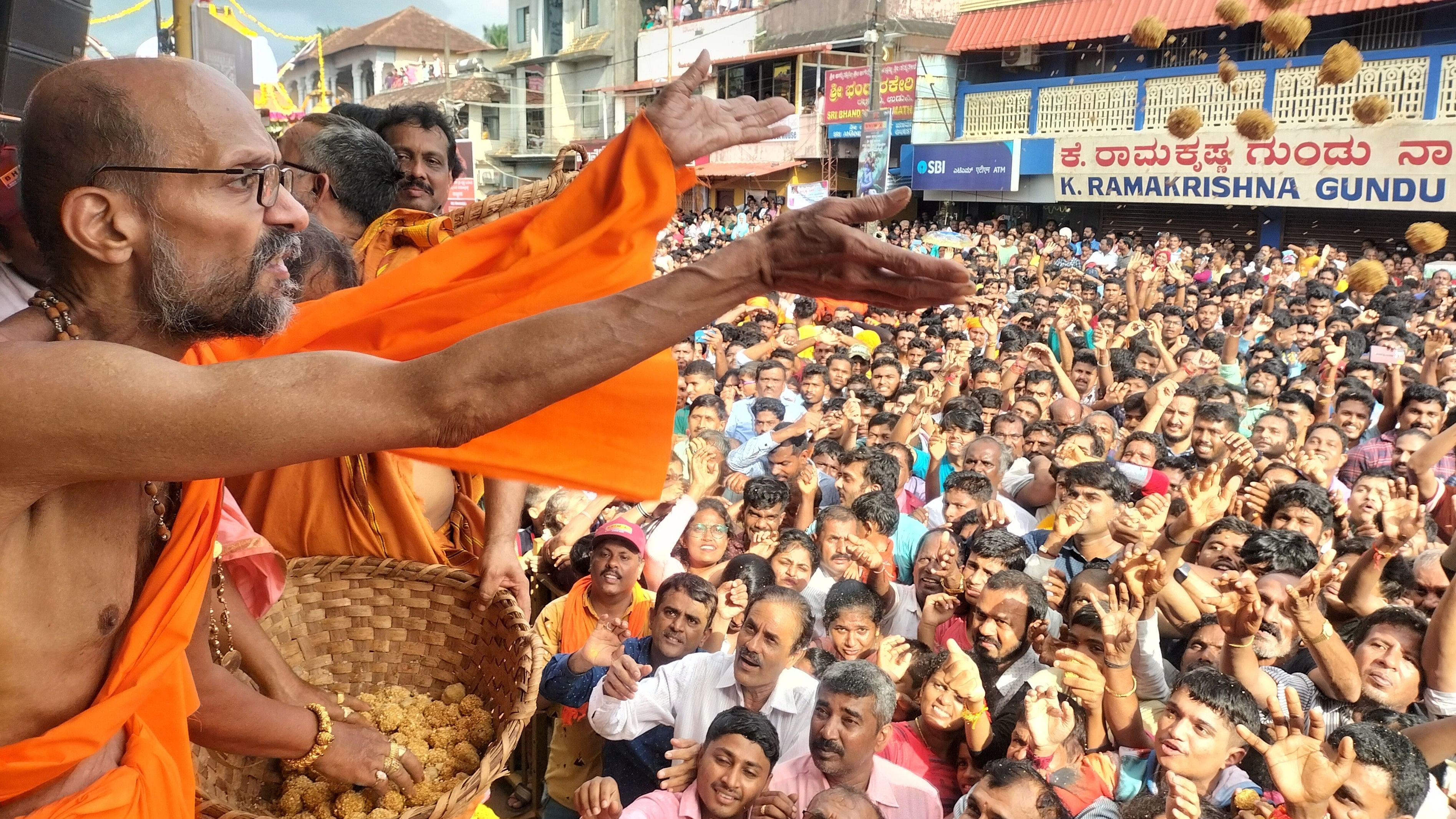<div class="paragraphs"><p>Udupi Paryaya Krishnapura mutt pontiff Sri Vidyasagara Teertha Swamiji distributes 'Chakkuli' and 'laddoo' as prasadam as the devotees stretch their hands, during Vittlapindi celebrations.</p></div>