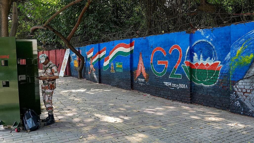 <div class="paragraphs"><p>A security personnel stands near graffiti made in preparations for the upcoming G20 Summit, at Lodhi Road in New Delhi, Tuesday, Sept. 5, 2023.</p></div>