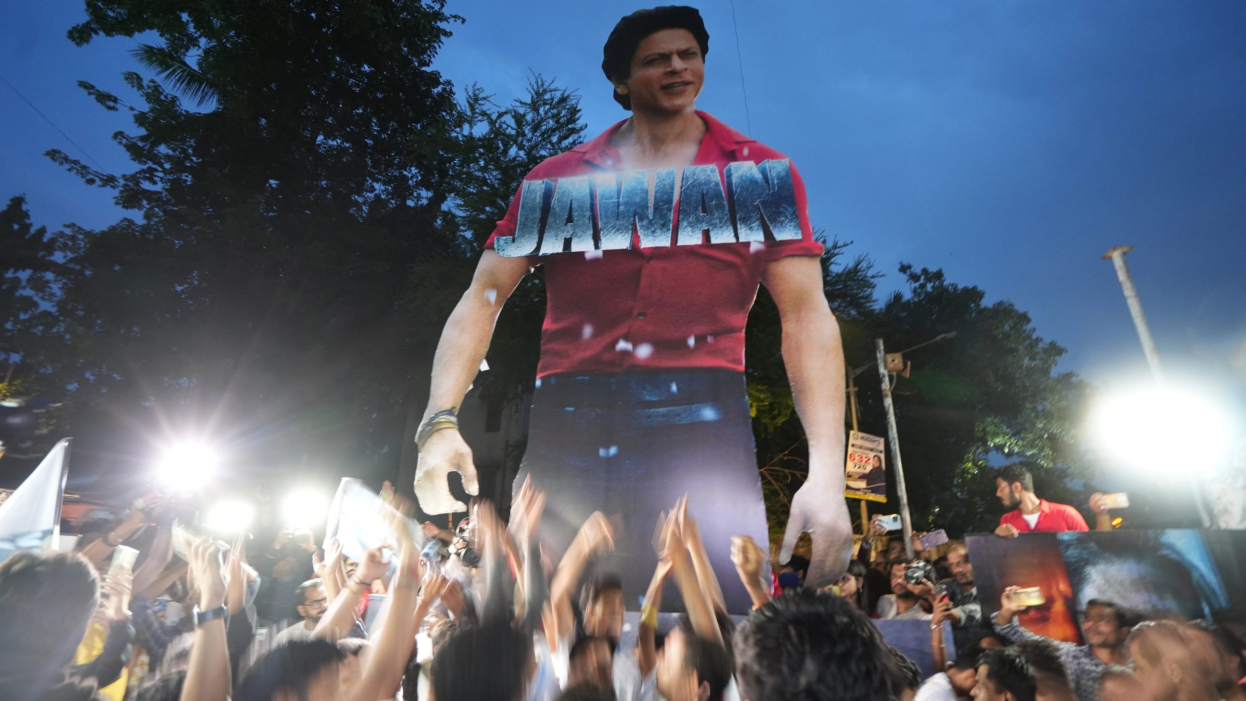 <div class="paragraphs"><p>Fans cheer near a cut-out of Bollywood actor Shah Rukh Khan outside a cinema hall as they arrive to watch the screening of his latest film 'Jawan'.</p></div>