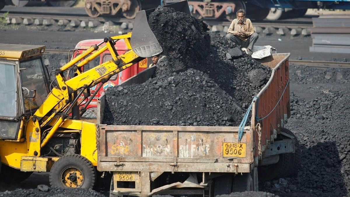 <div class="paragraphs"><p>A worker sits on a truck being loaded with coal at a railway coal yard on the outskirts of Ahmedabad.</p></div>