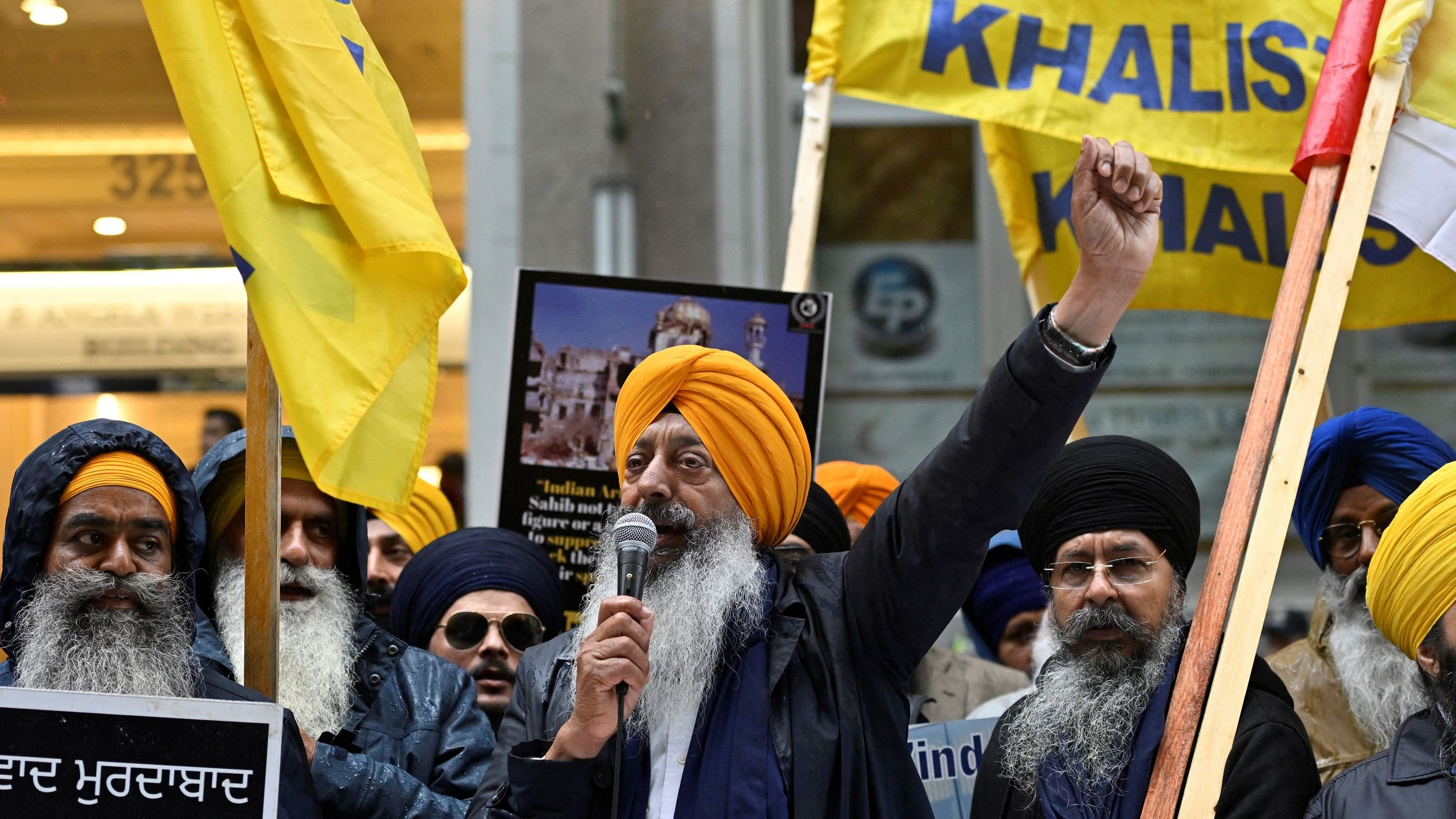 <div class="paragraphs"><p>A demonstrator uses a microphone as others hold flags and signs as they protest outside India's consulate in Vancouver, </p></div>