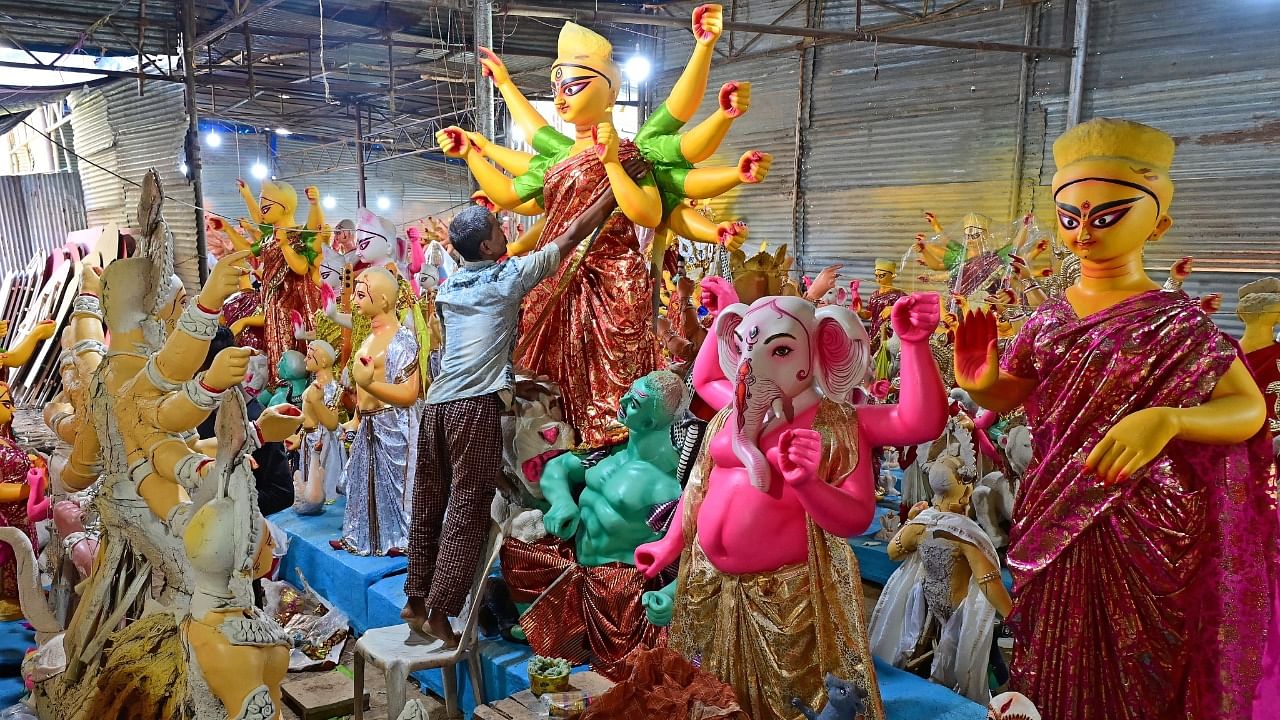 <div class="paragraphs"><p>A Bengali artist decorates a clay idol of Hindu Goddess Durga at a shed in Cox Town. (R) A little girl shopping for dolls in Malleswaram. </p></div>