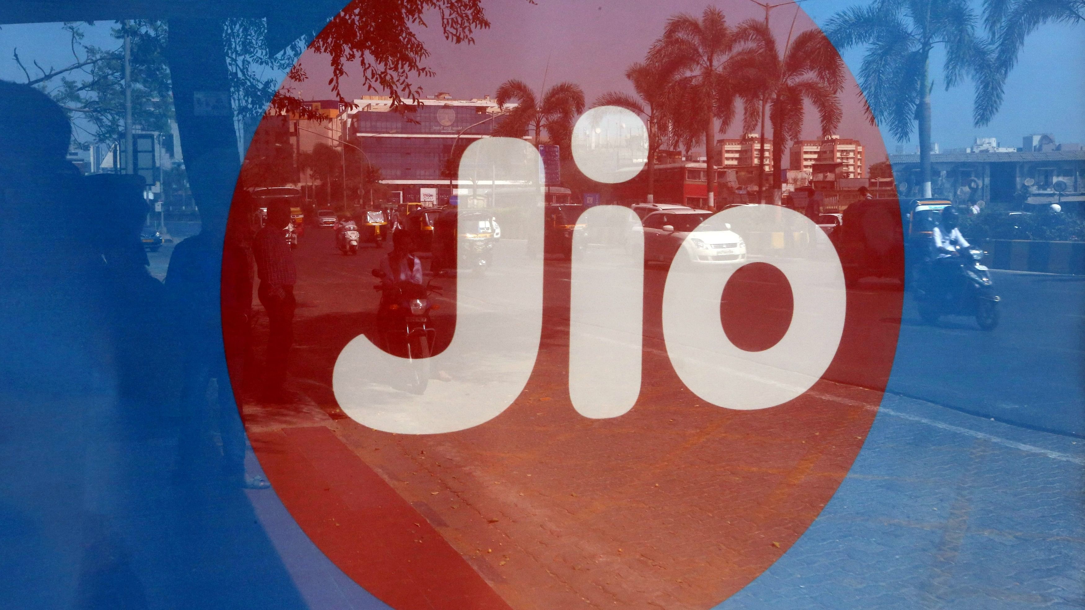 <div class="paragraphs"><p>Commuters are reflected on an advertisement of Reliance Industries' Jio telecoms unit.&nbsp;</p></div>