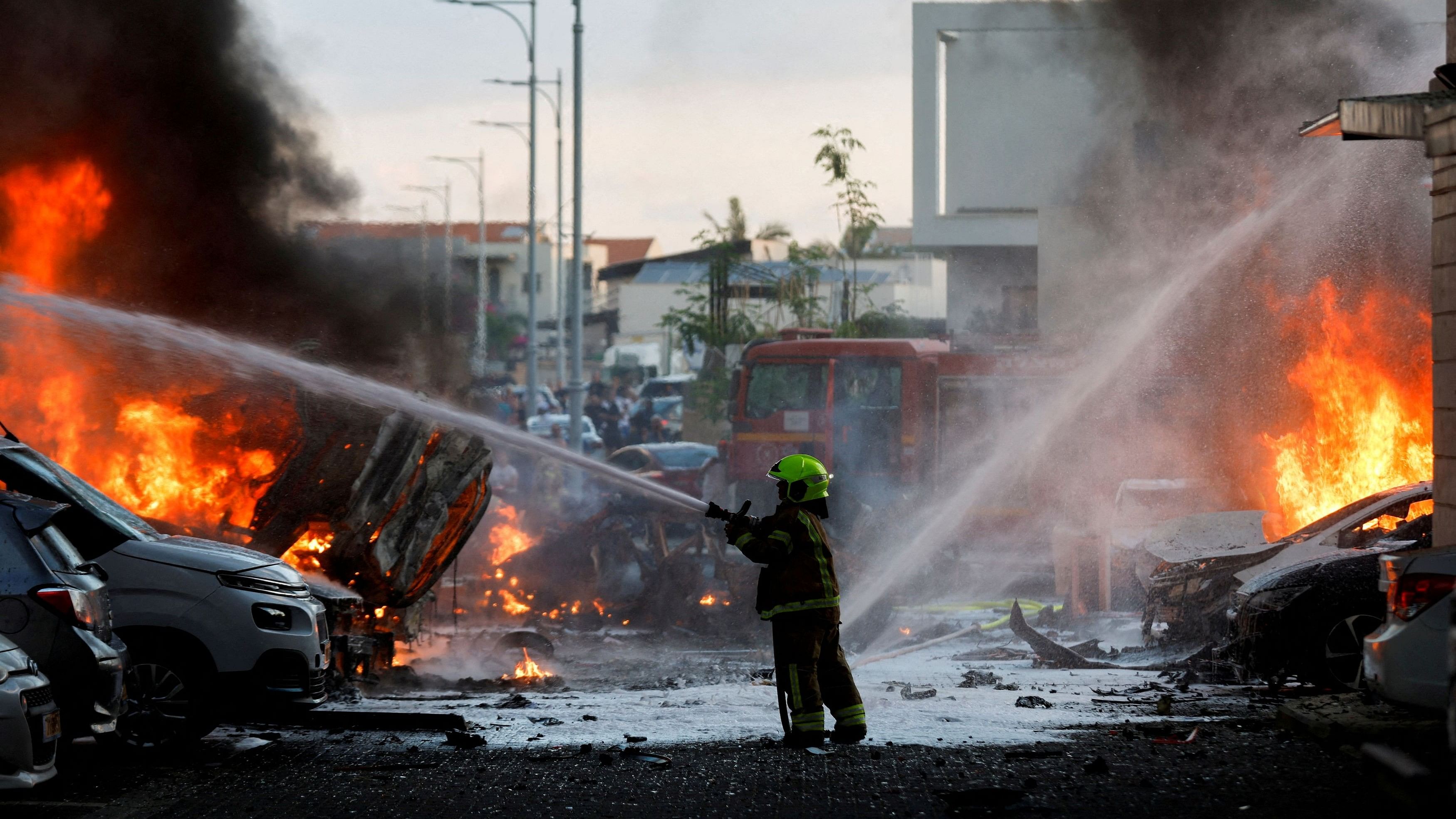 <div class="paragraphs"><p>An emergency personnel works to extinguish the fire after rockets are launched from the Gaza Strip, as seen from the city of Ashkelon, Israel October 7, 2023.</p></div>