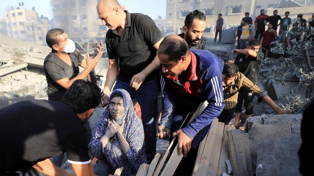 <div class="paragraphs"><p>A Palestinian woman is assisted, as people search for casualties at the site of an Israeli strike on a residential building in Gaza City.</p></div>