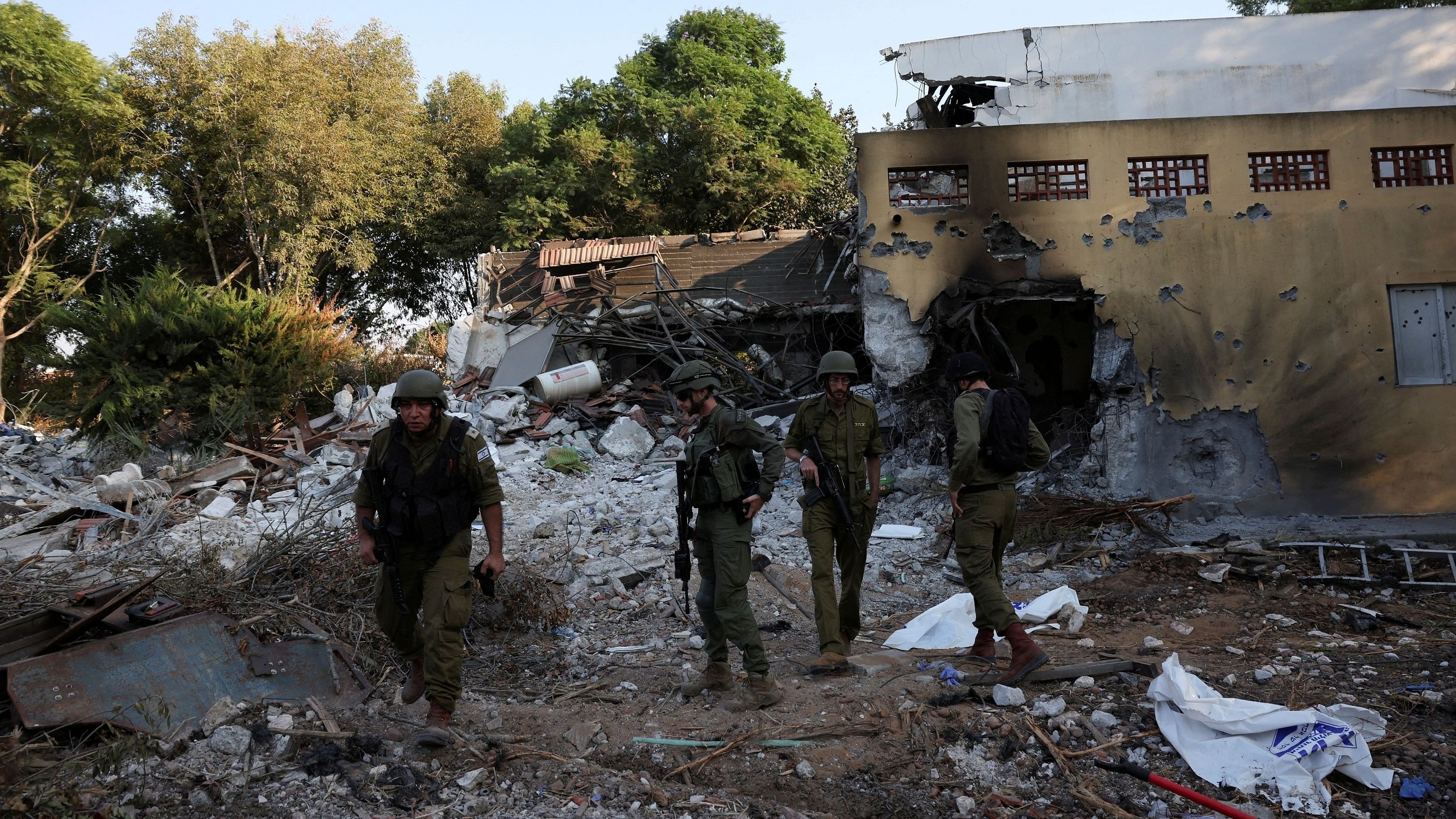 <div class="paragraphs"><p>Israeli soldiers walk, in the aftermath of a mass infiltration by Hamas gunmen from the Gaza Strip, in Kibbutz Beeri in southern Israel, October 14, 2023.</p></div>