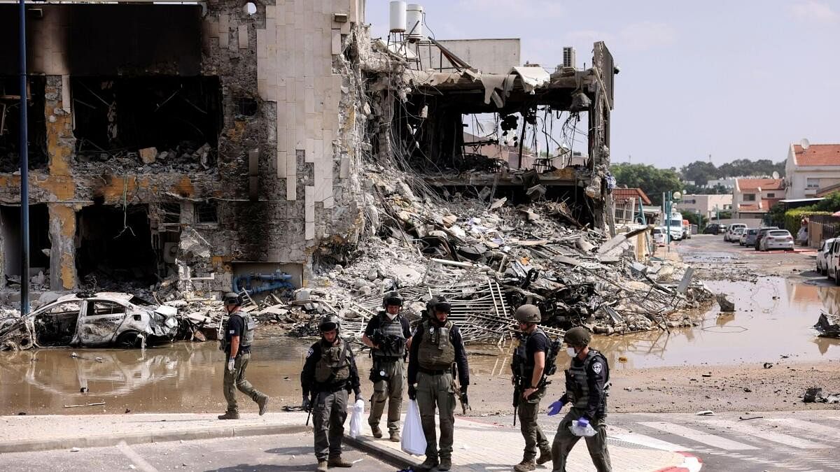 <div class="paragraphs"><p>Israeli security gather near a rifle at the site of a battle following a mass infiltration by Hamas gunmen from the Gaza Strip, in Sderot, southern Israel.</p></div>