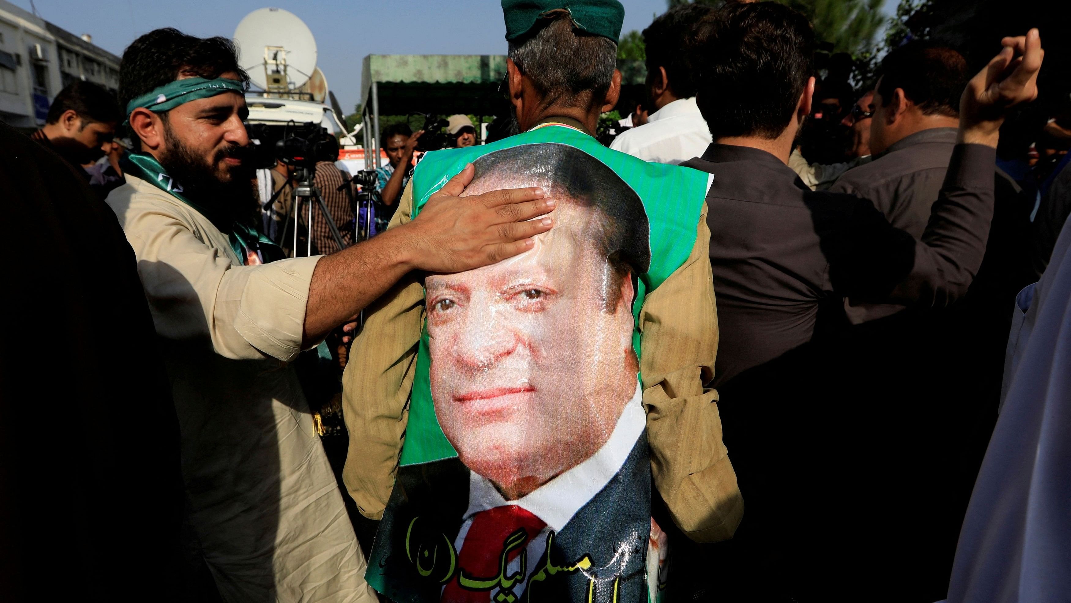 <div class="paragraphs"><p>A supporter of former Prime Minister Nawaz Sharif touches his picture .</p></div>