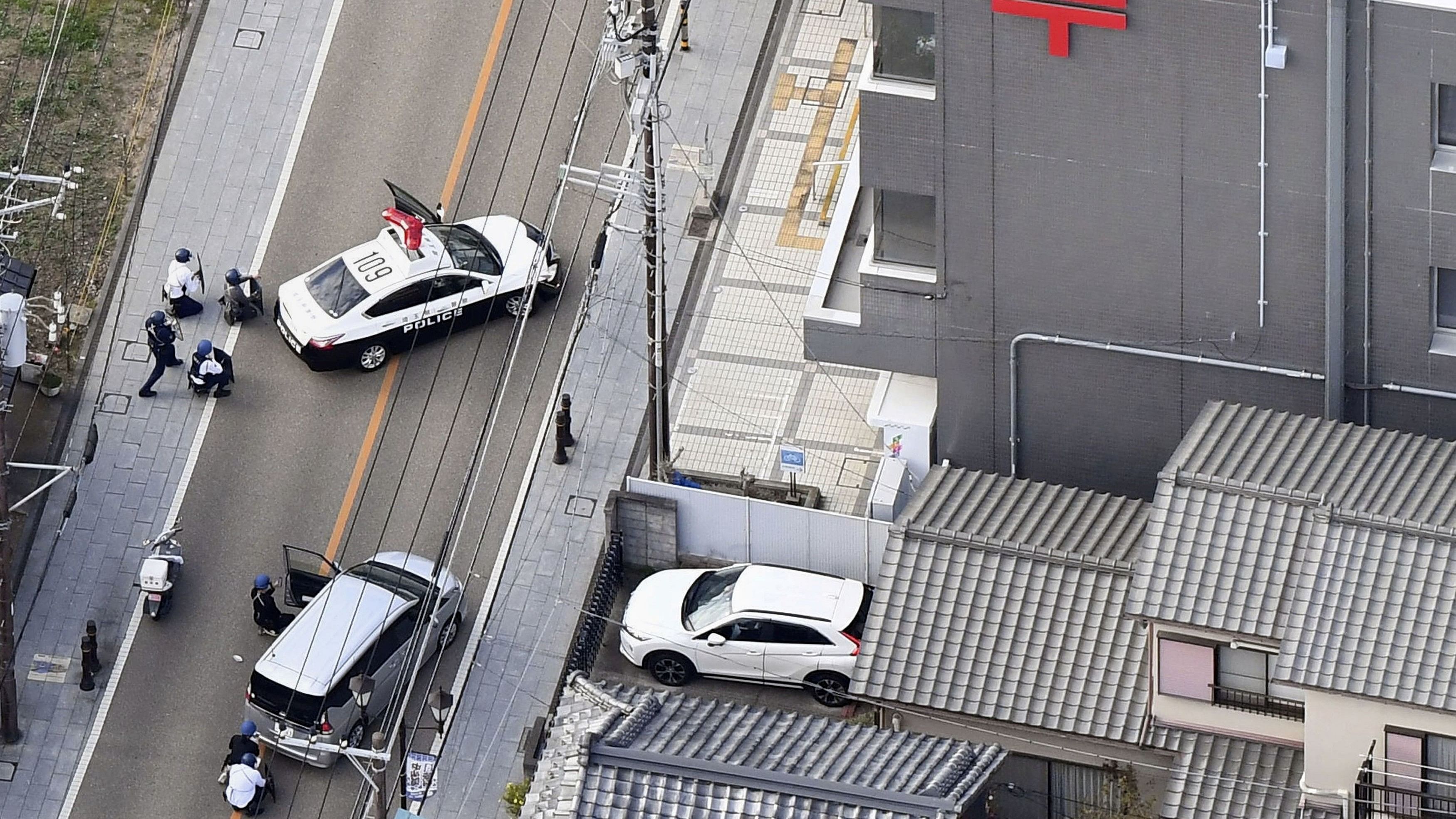 <div class="paragraphs"><p>Police officers take cover behind cars outside the post office where a suspected gunman has taken people hostage after injuring two at a hospital, in Warabi, Saitama Prefecture, Japan October 31, 2023, in this photo taken by Kyodo.  </p></div>