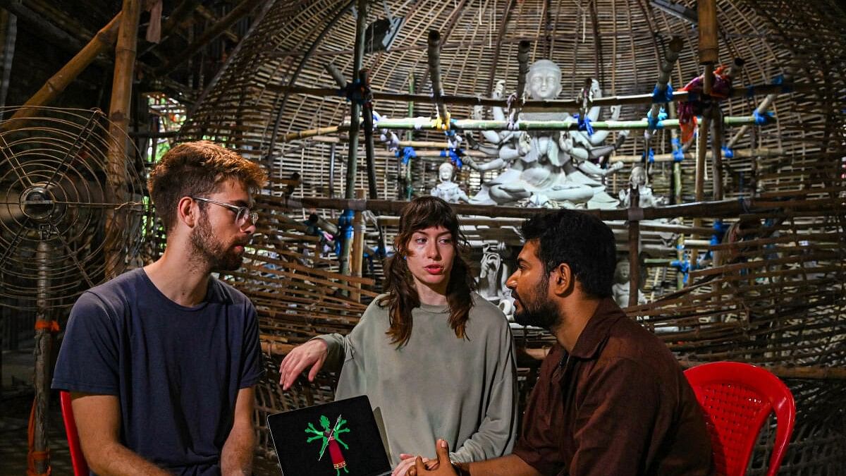 <div class="paragraphs"><p>Artists from Netherlands Benjamin Van Hoeji Schilthouer Pompe and Martyna Maria Pekala with Indian artist Ayan Saha at a community Durga Puja pandal, designed in collaboration with artists of both countries, in Kolkata.</p></div>