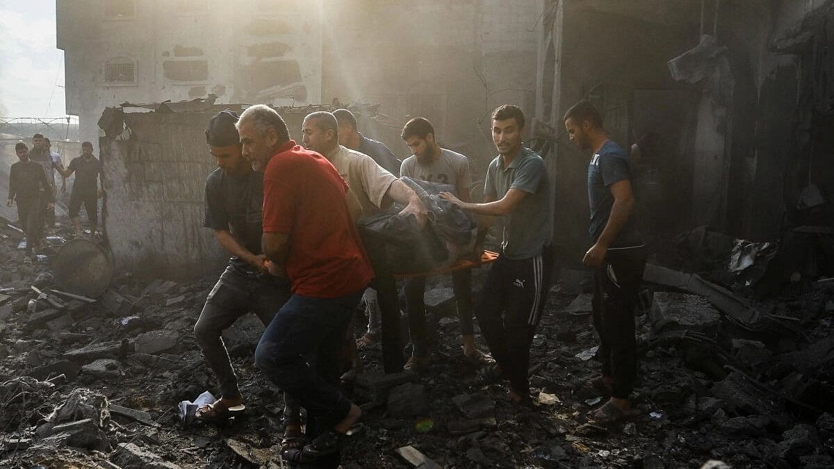 <div class="paragraphs"><p>Palestinians carry a casualty on rubble in the aftermath of Israeli strikes in Khan Younis, southern Gaza Strip, October 11, 2023.</p></div>