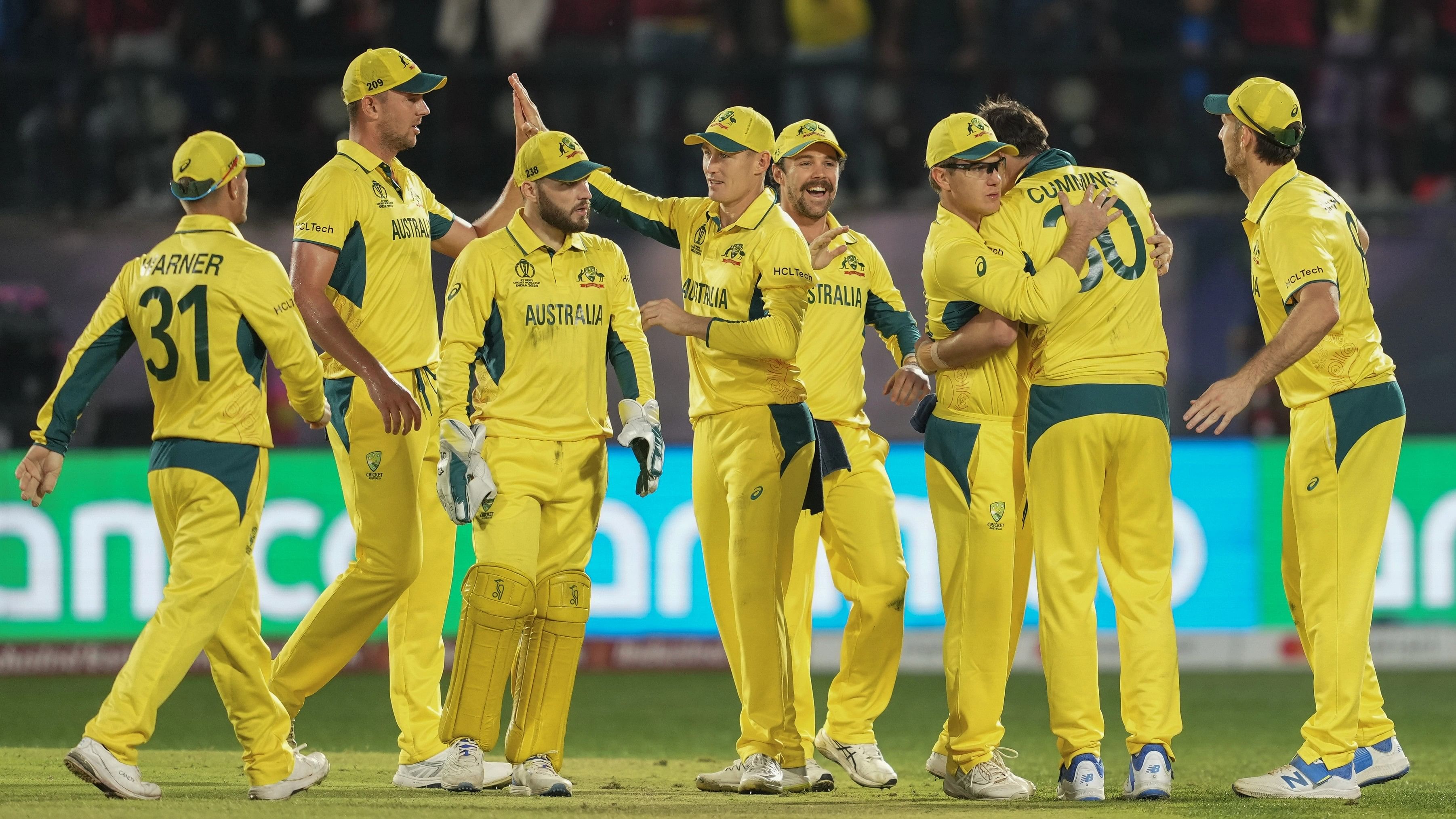 <div class="paragraphs"><p>Australian pacer Pat Cummins with teamamtes celebrates the wicket of New Zealand's Rachin Ravindra during the ICC Men's Cricket World Cup 2023 match between Australia and New Zealand, at HPCA Stadium, in Dharamshala.</p></div>