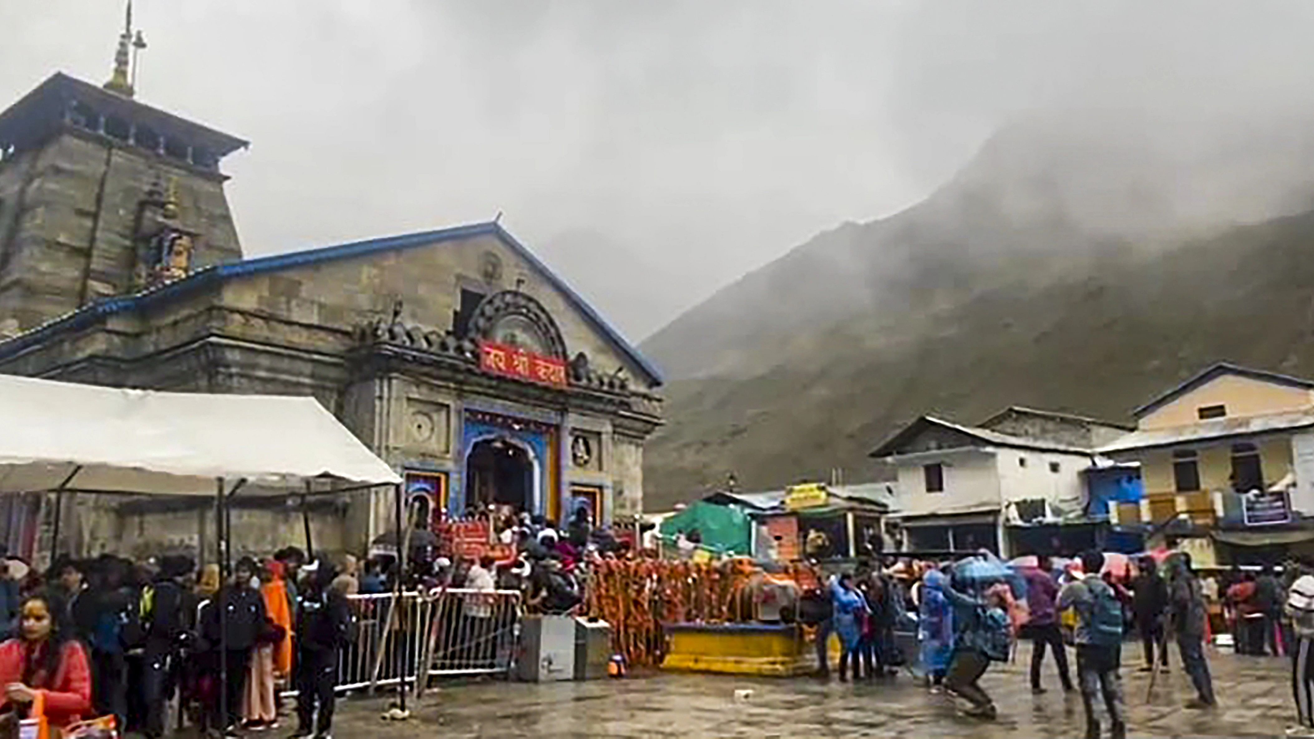 <div class="paragraphs"><p>Devotees stand in queue to offer prayers at the Kedarnath temple amid rainfall, in Rudraprayag district</p></div>