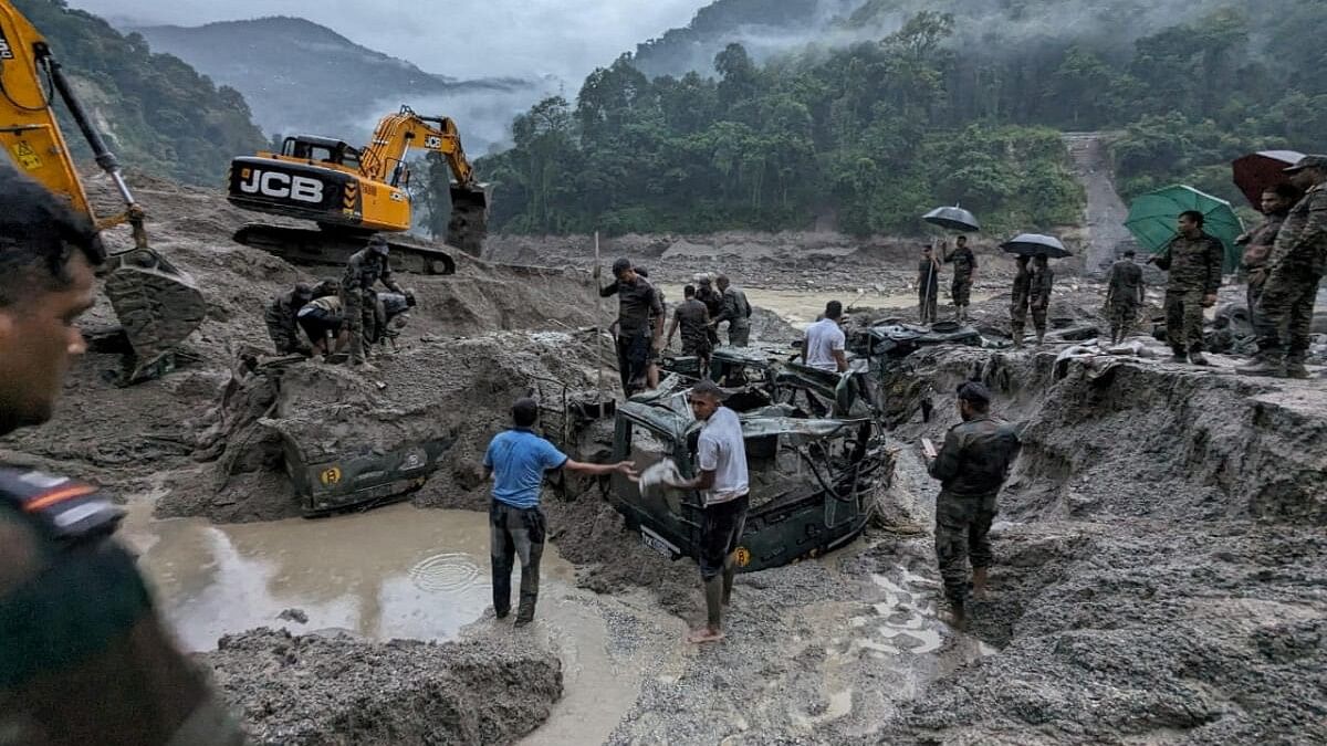 <div class="paragraphs"><p>Members of Indian Army try to recover trucks buried at the area affected by flood in Sikkim.</p></div>