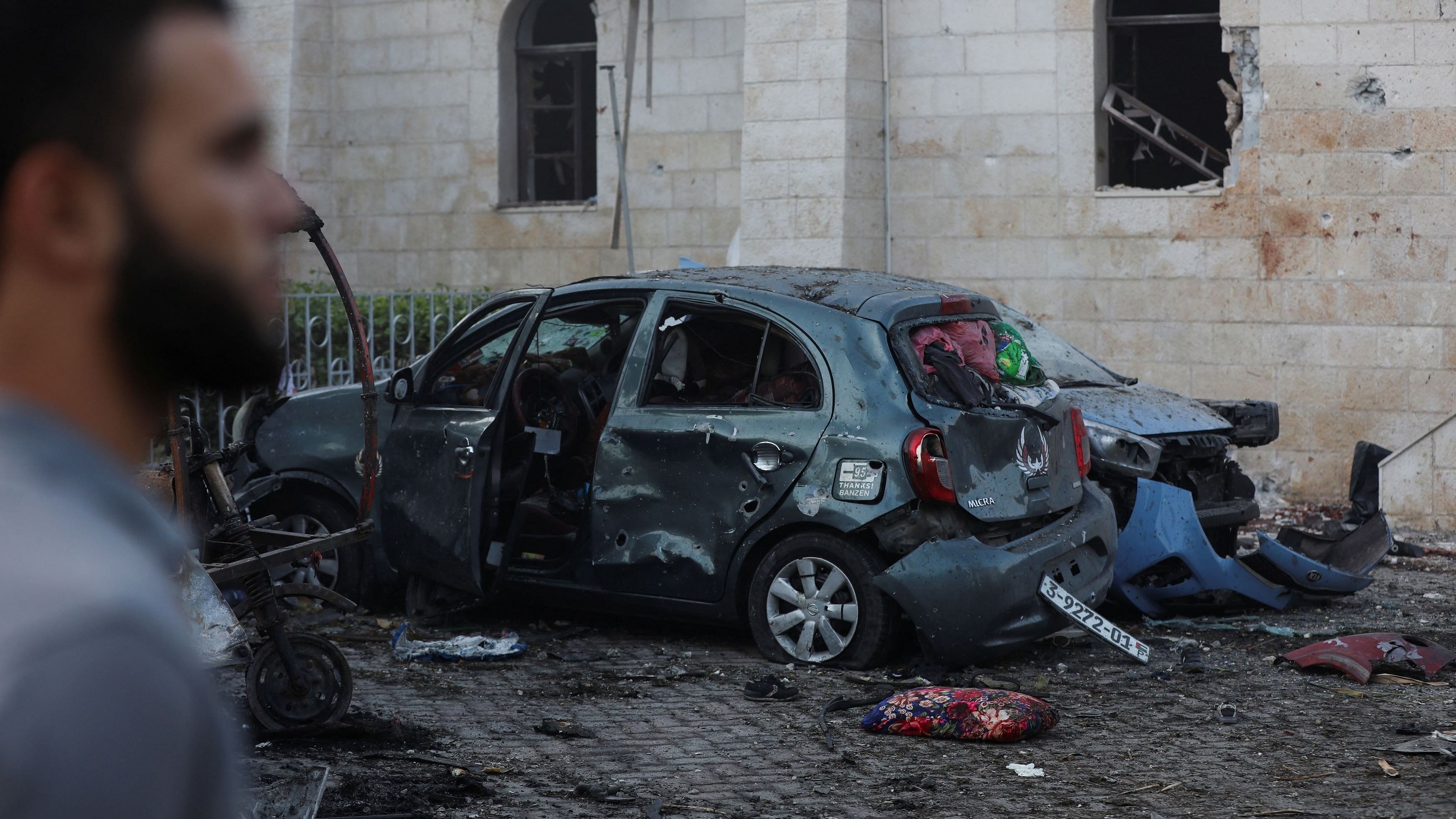 <div class="paragraphs"><p>A man stands next to a damaged car in the area of Al-Ahli hospital where hundreds of Palestinians were killed in a blast that Israeli and Palestinian officials blamed on each other, and where Palestinians who fled their homes were sheltering amid the ongoing conflict with Israel, in Gaza City, October 18, 2023.</p></div>