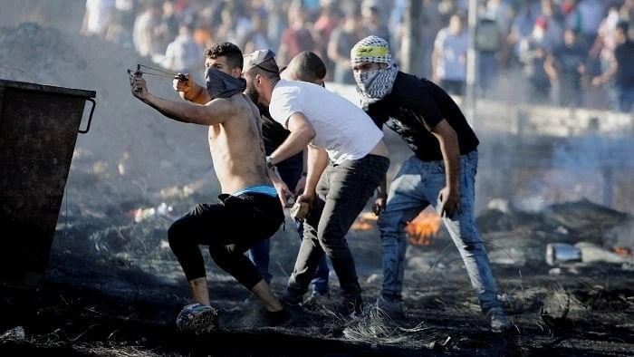 <div class="paragraphs"><p>A Palestinian uses a slingshot during an anti-Israel protest over a cross-border violence between Palestinian militants in Gaza and the Israeli military, near Hawara checkpoint near Nablus in the Israeli-occupied West Bank. </p></div>