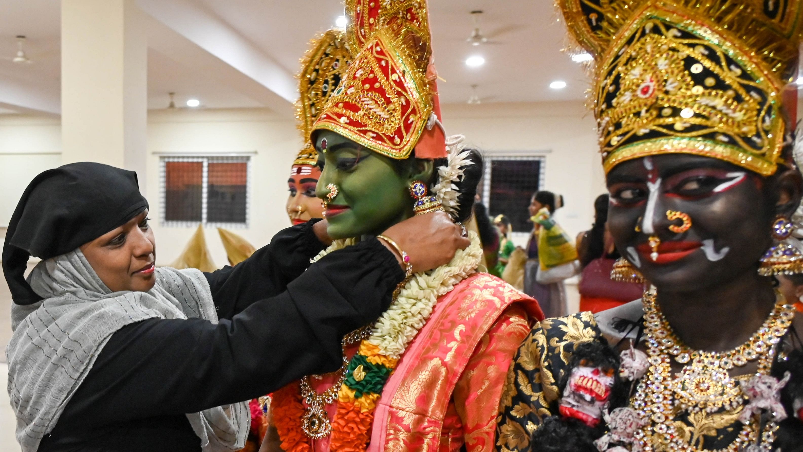 <div class="paragraphs"><p>A woman dolls up a dancer from Sri Lalitha Kala Niketan before their ‘Nava Durgee’ performance at the Gandhinagar Dasara celebrations on Friday. </p></div>