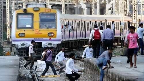 <div class="paragraphs"><p>Commuters catch a local train at CST station in Mumbai.</p></div>