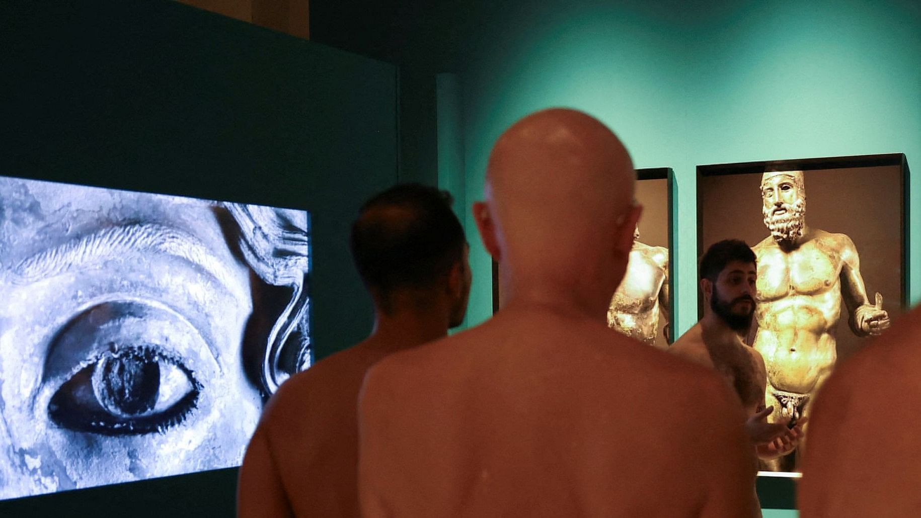 <div class="paragraphs"><p>Guide Edgard Mestre talks to residents as they take part in a nudist visit to the Archaeology Museum of Catalonia about The Bronzes of Race exhibition of Luigi Spina's photographs depicting two large Greek bronze statues of the naked in Barcelona, Spain on October 28, 2023.</p></div>