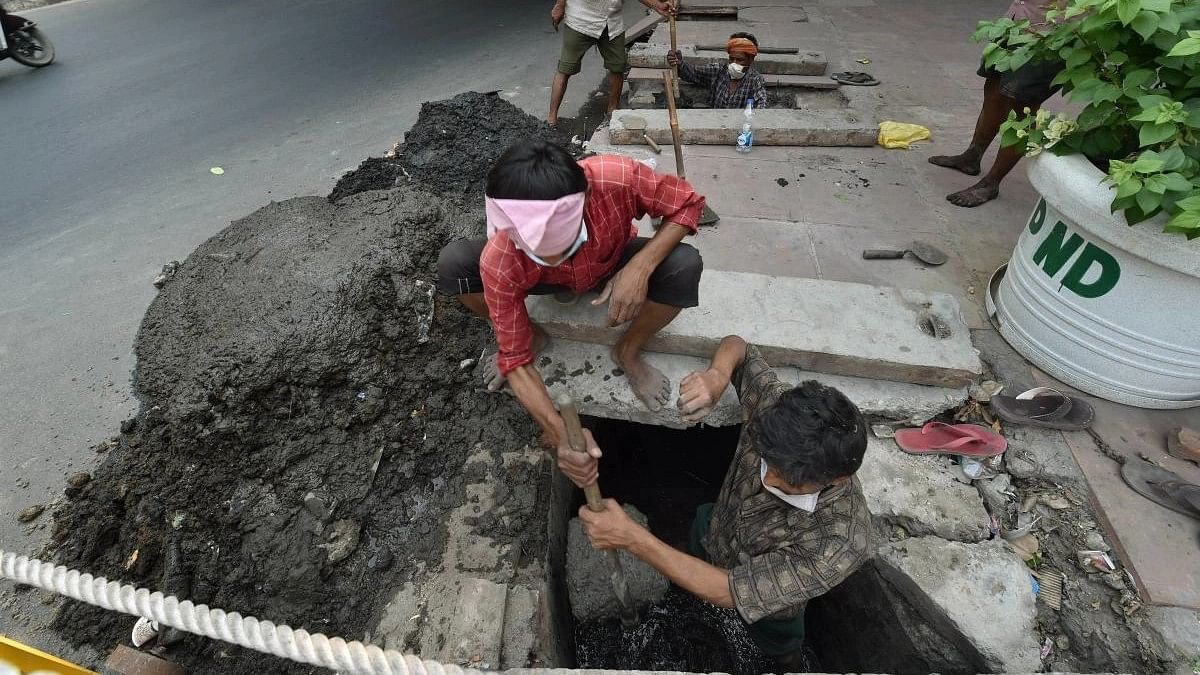 <div class="paragraphs"><p>File photo of workers cleaning a sewer manually in New Delhi.&nbsp;</p></div>