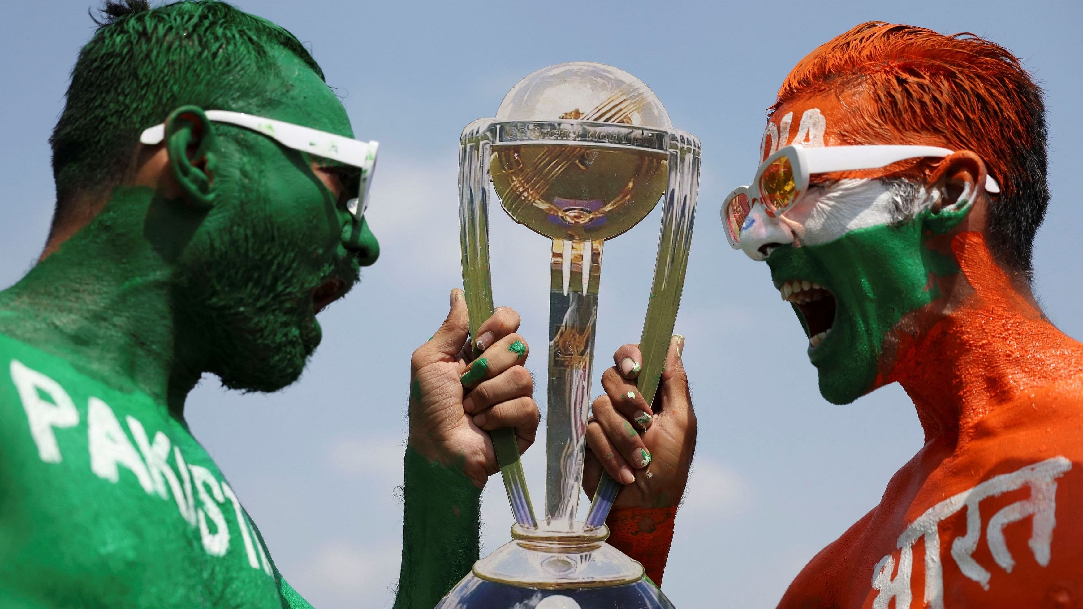 <div class="paragraphs"><p>Cricket fans, Arun Haryani  pose for a photograph with a replica trophy after painting their bodies in the Indian and Pakistani national flag colours, ahead of the match between India and Pakistan in the ICC World Cup, in Ahmedabad, India, October 11, 2023. </p></div>