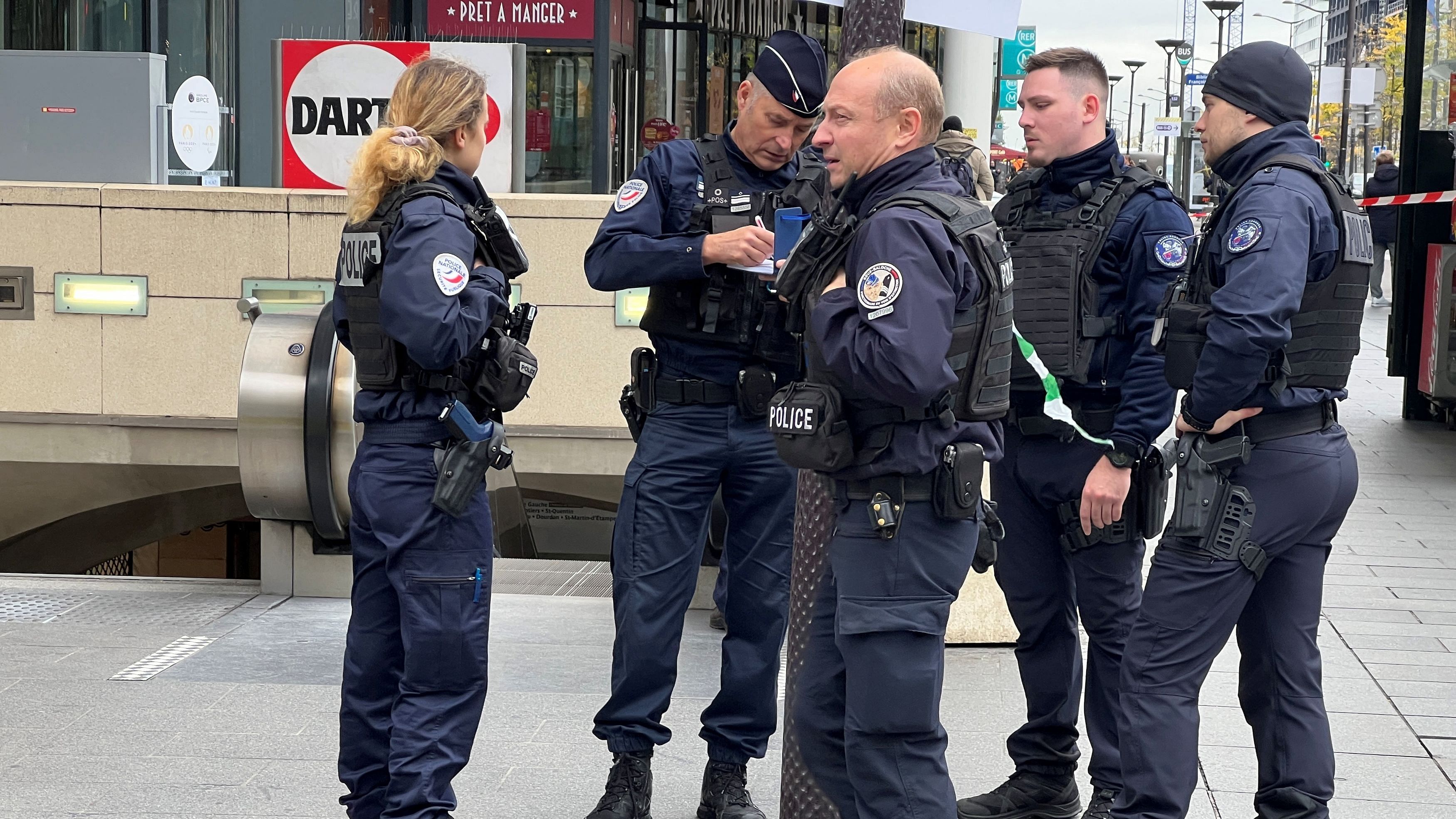 <div class="paragraphs"><p>Police stand outside the Bibliotheque Francois Mitterand metro and regional train station, where officers shot and injured a woman wearing a hijab.</p></div>