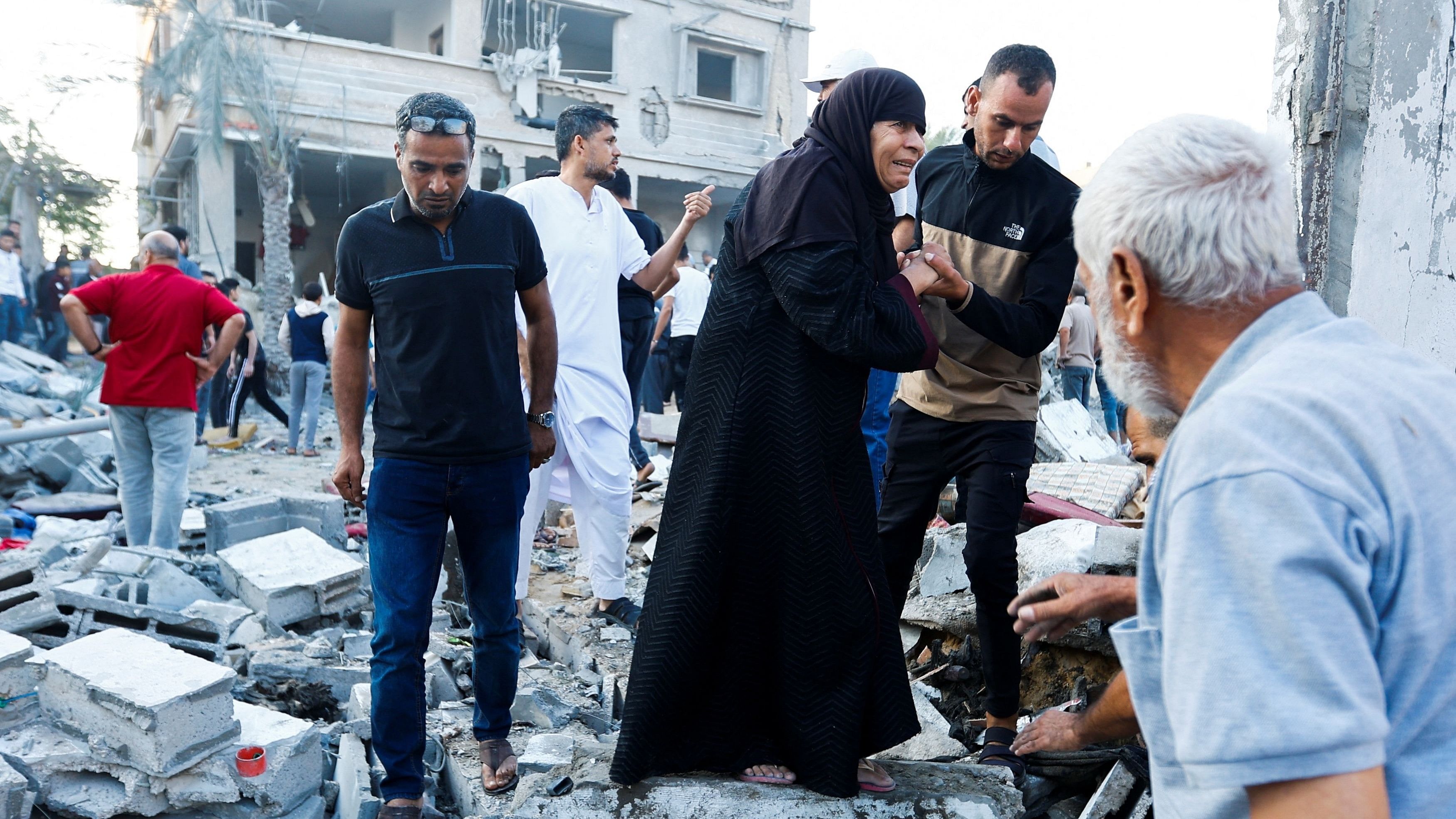 <div class="paragraphs"><p>People walk on rubble in the aftermath of a strike amid the conflict with Israel in Khan Younis, in the southern Gaza Strip, October 12, 2023. </p></div>